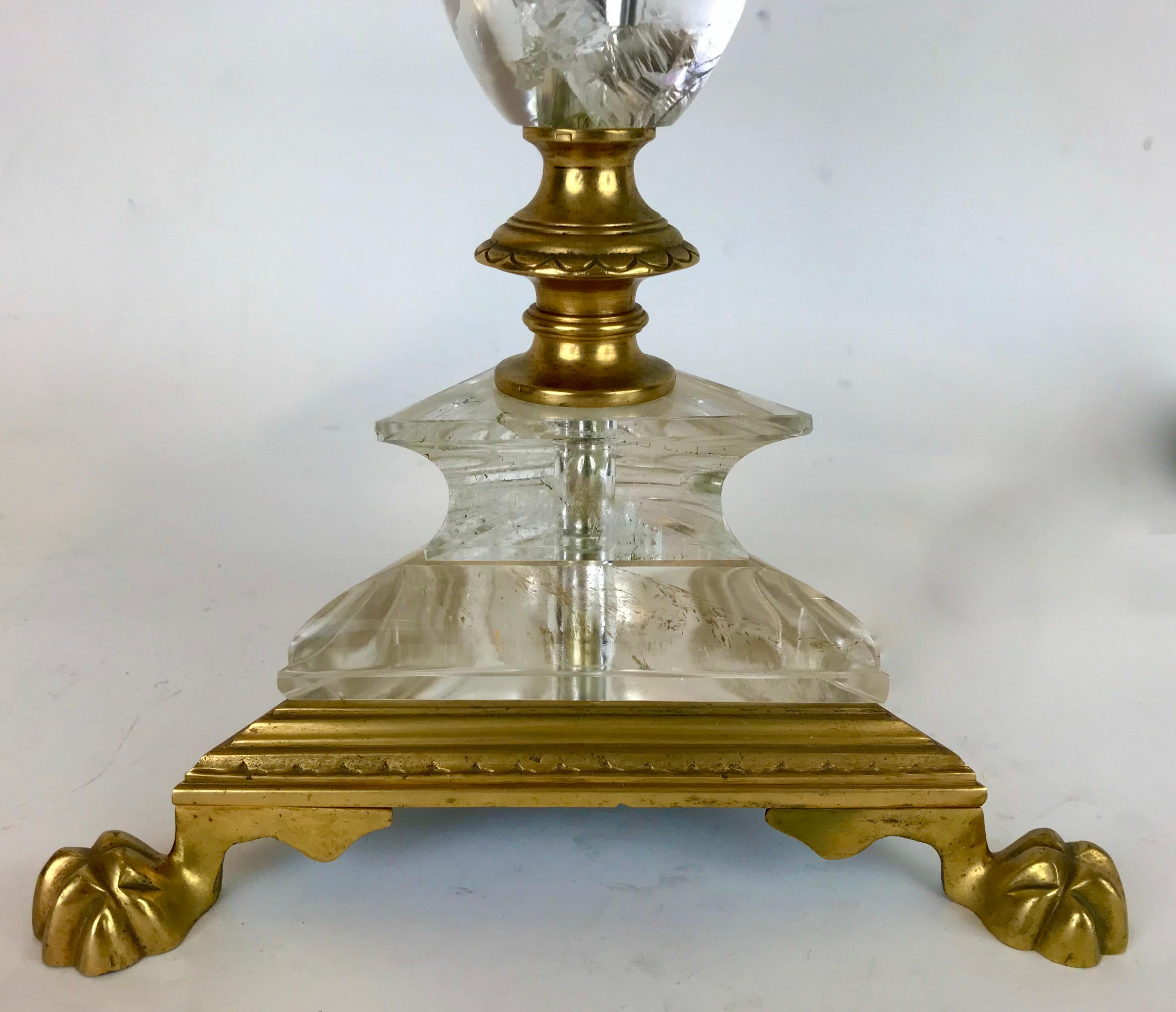 Diese fein detaillierte Lampe im Stil eines Pricketstocks besteht aus Bergkristallquarz, der mit Bronzebeschlägen auf einem dreieckigen Sockel montiert ist, der in Tatzenfüßen endet.