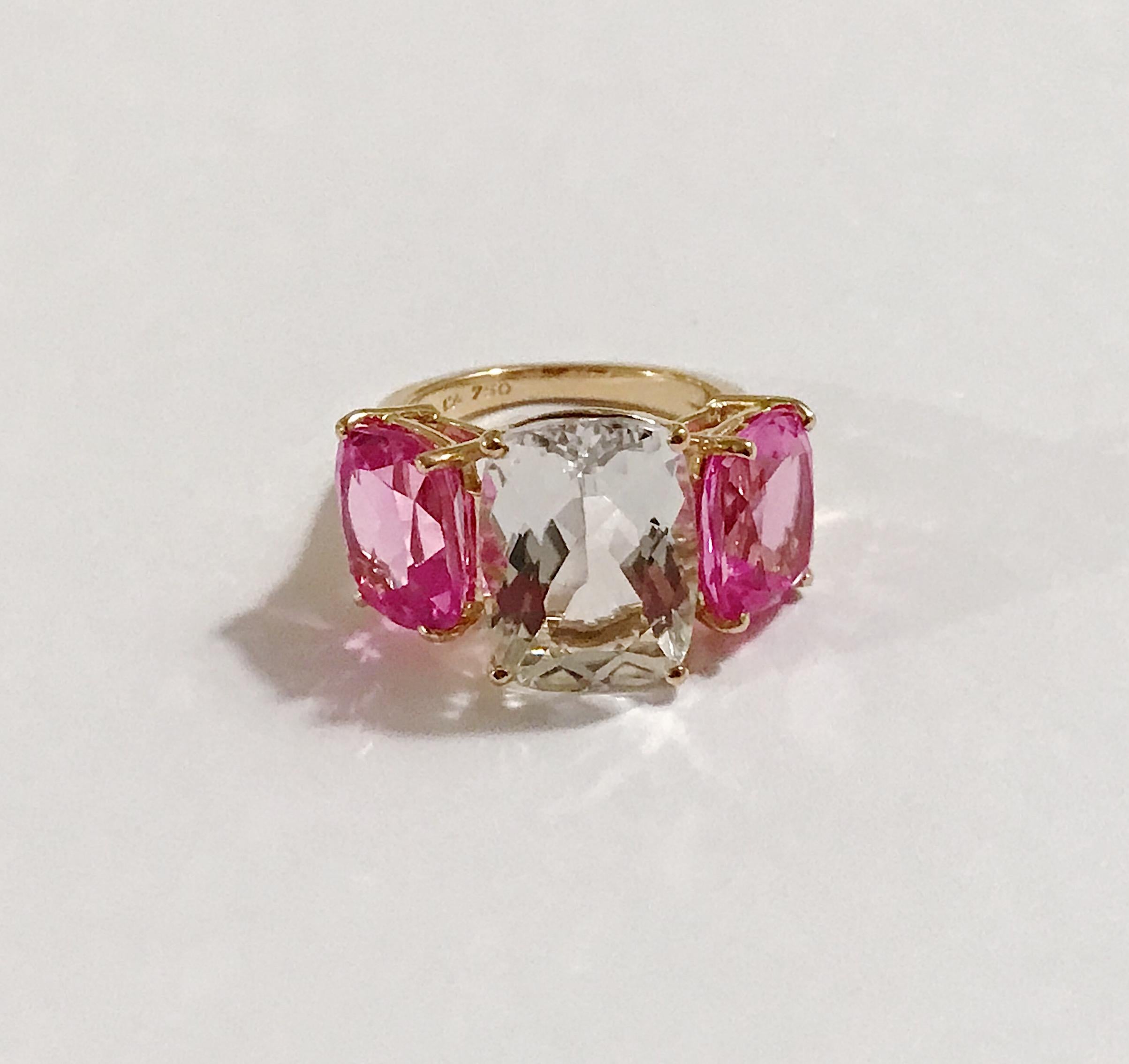 18kt Yellow Gold Three Stone faceted Cushion Ring with center Rock Crystal and two Hot Pink Topaz finished with a tapered split shank.

This elegant cocktail ring measures 1 1/4