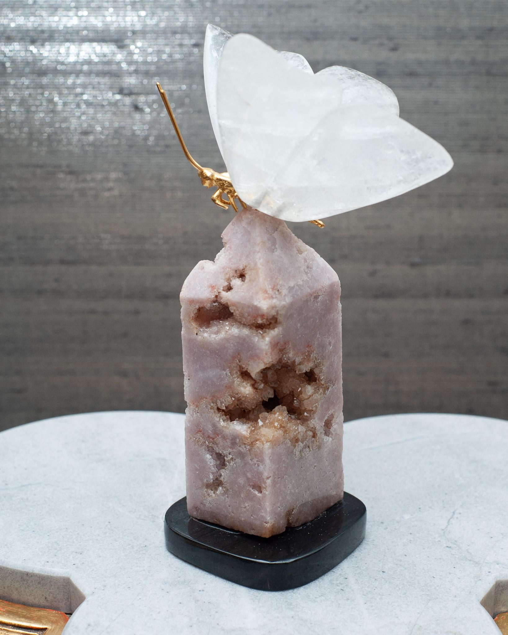 Eine atemberaubende dekorative Mineralprobe, bestehend aus einem Bergkristall-Schmetterling mit Messingkörper, auf einem rosa  Obelisk aus Geoden auf schwarzem Marmorsockel. Ein wunderschönes Accessoire für jeden Tisch, das gleichzeitig die heilende