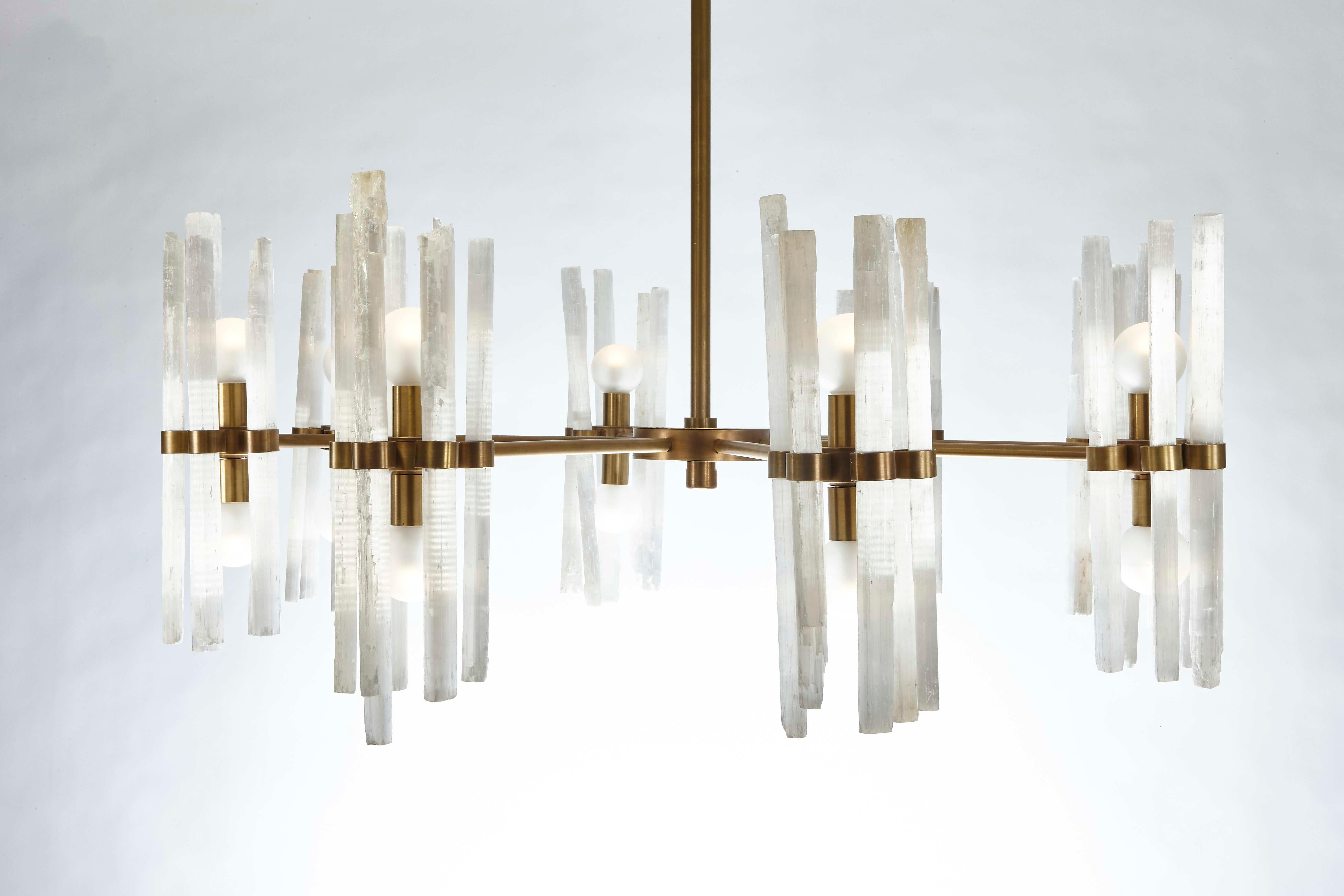 Our rock crystal chandelier is a stunning piece of art that embodies both elegance and natural beauty. The rock crystal rods are more organic and are placed in a more staggered display compared to our Flute chandelier. Handcrafted by skilled British
