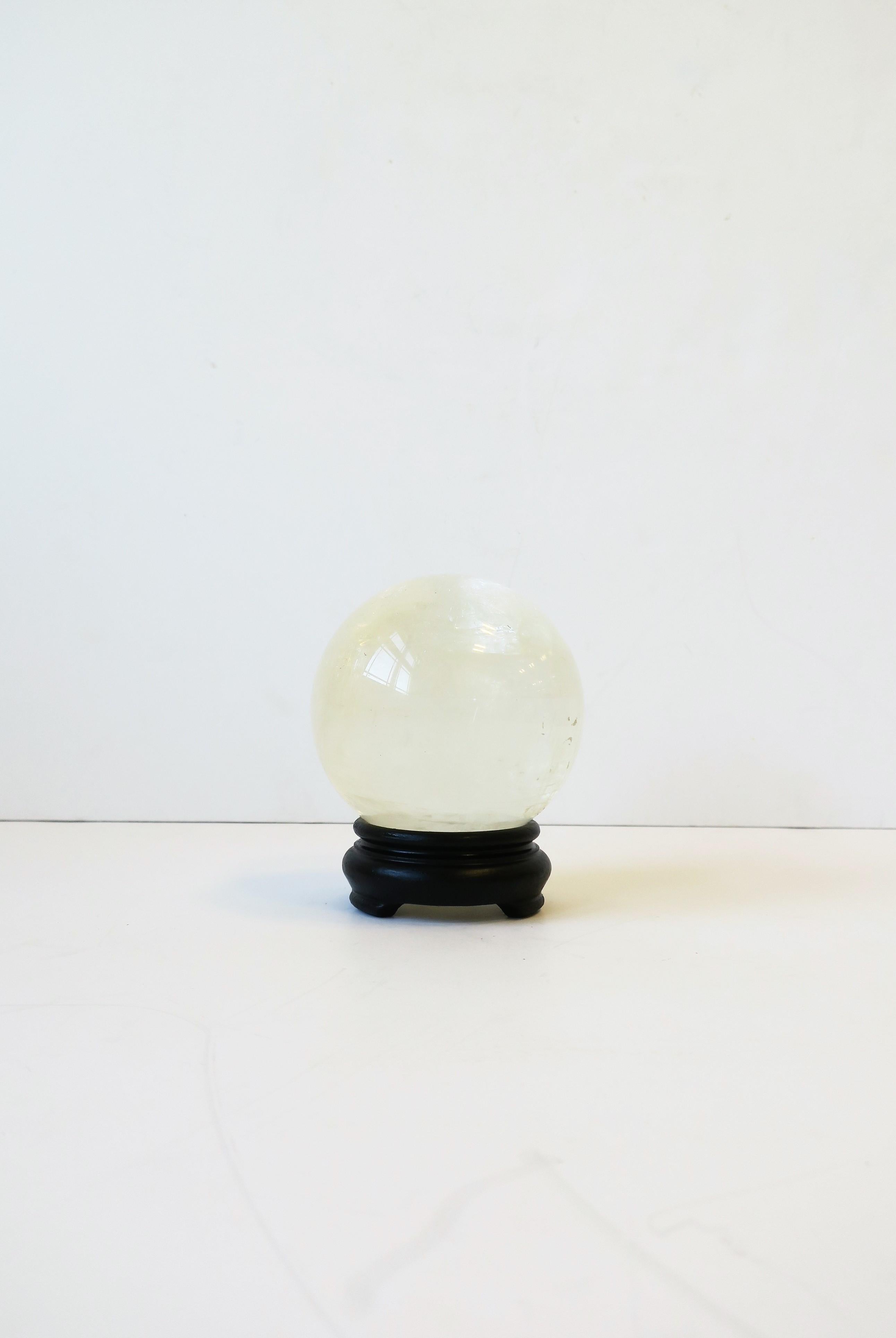 A beautiful and substantial rock crystal decorative sphere on a black wood base 

Piece measures: 4