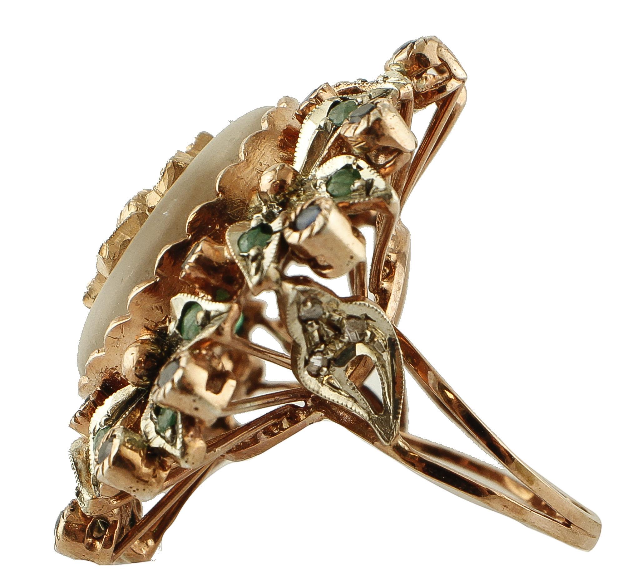 Stupefacente anello retrò con struttura in oro rosa 9k e argento, montato con un cristallo di rocca centrale con un fiore in oro rosa e smeraldi al centro e circondato da dettagli floreali in oro rosa e argento tempestati di smeraldi, diamanti e