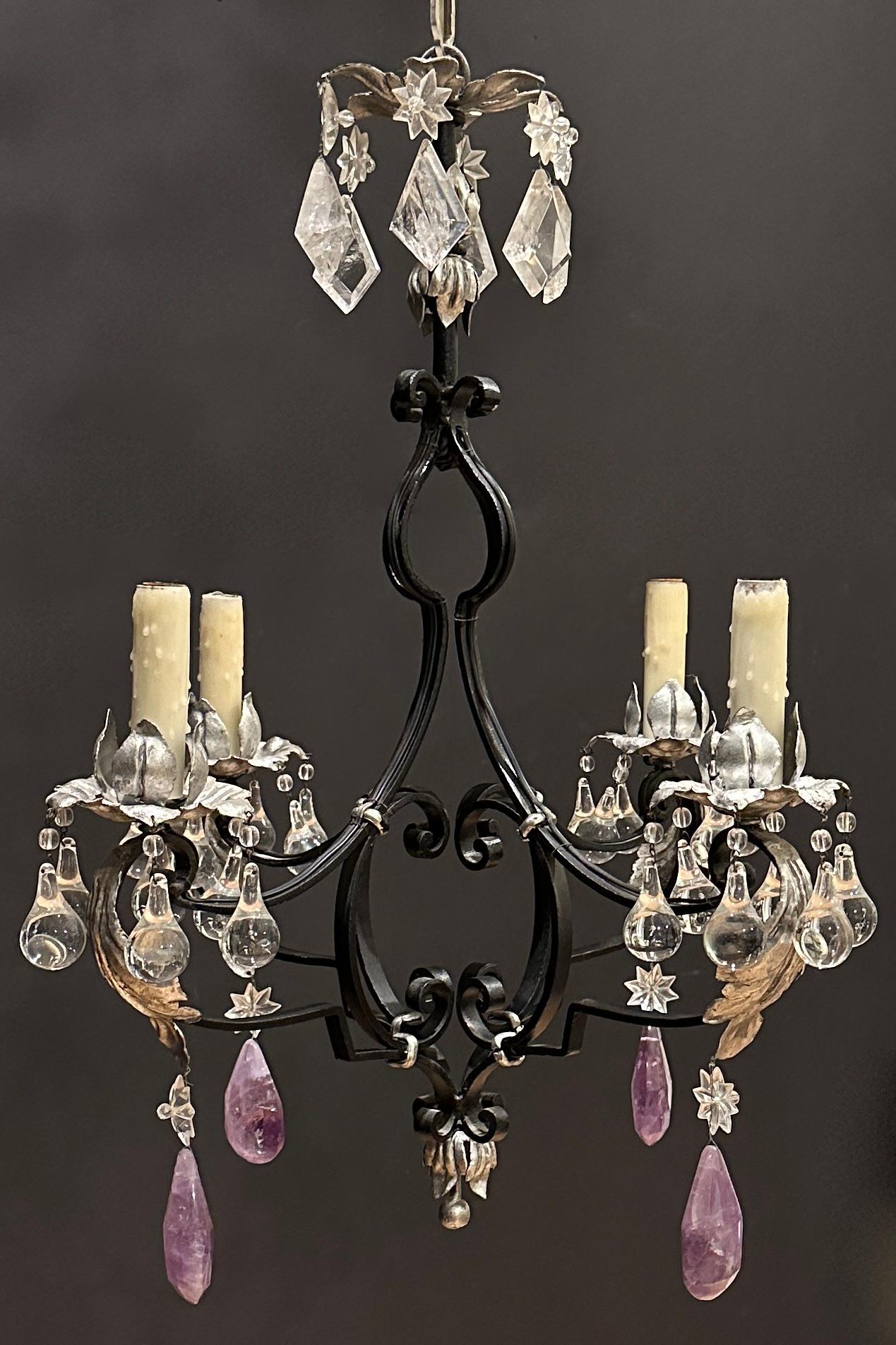 Amethyst and clear rock crystal chandelier featuring a black and silver gilt wrought iron frame in The Louis XV style in The Manner Of Maison Bagues chandelier. Flat hammered arms with scrolls bound to form an elegant Versailles style frame and leaf