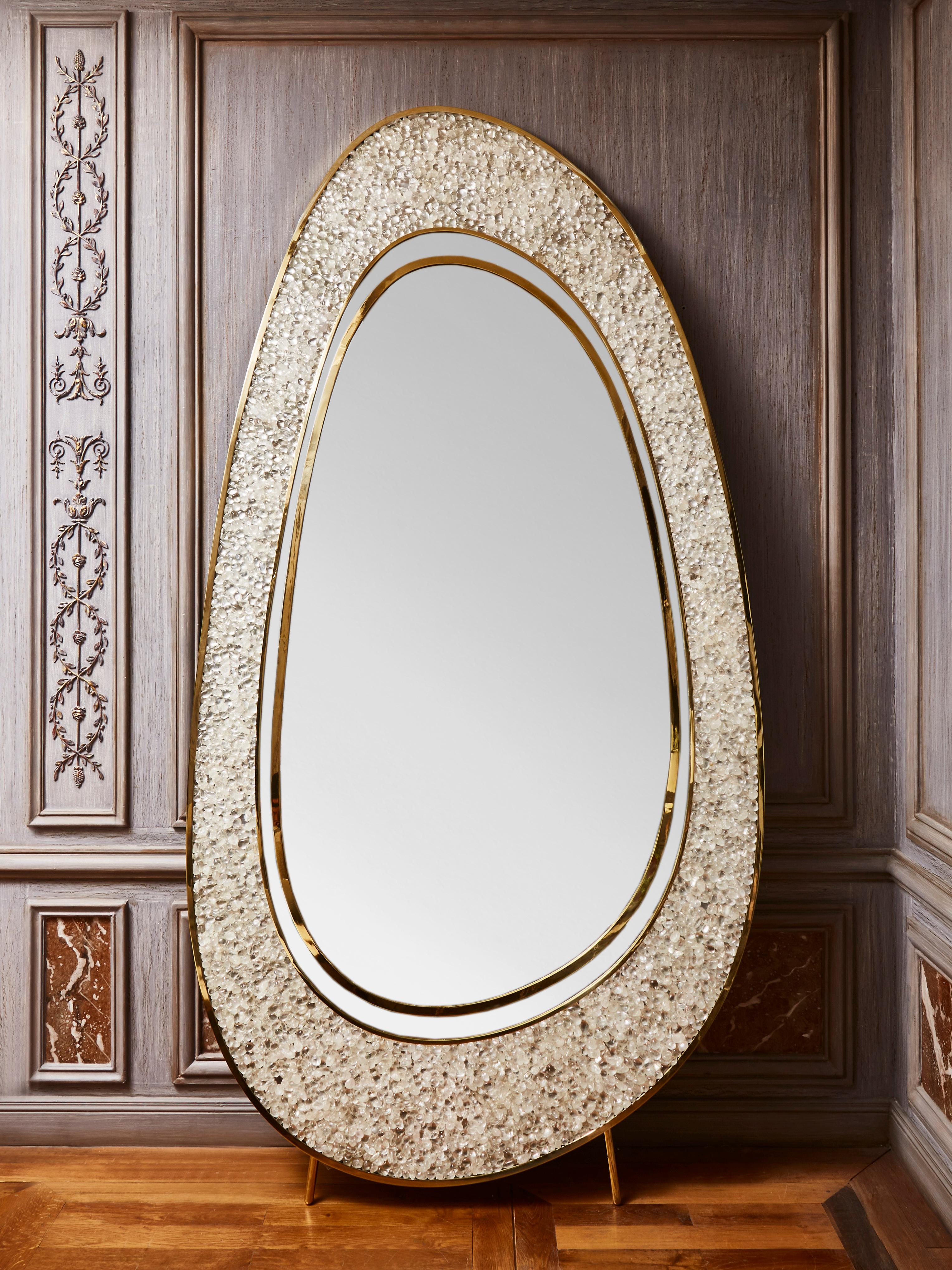Exceptional free-shaped mirror in brass with rolled rock crystals, on brass feet. 
Creation by Studio Glustin.
France, 2022.
