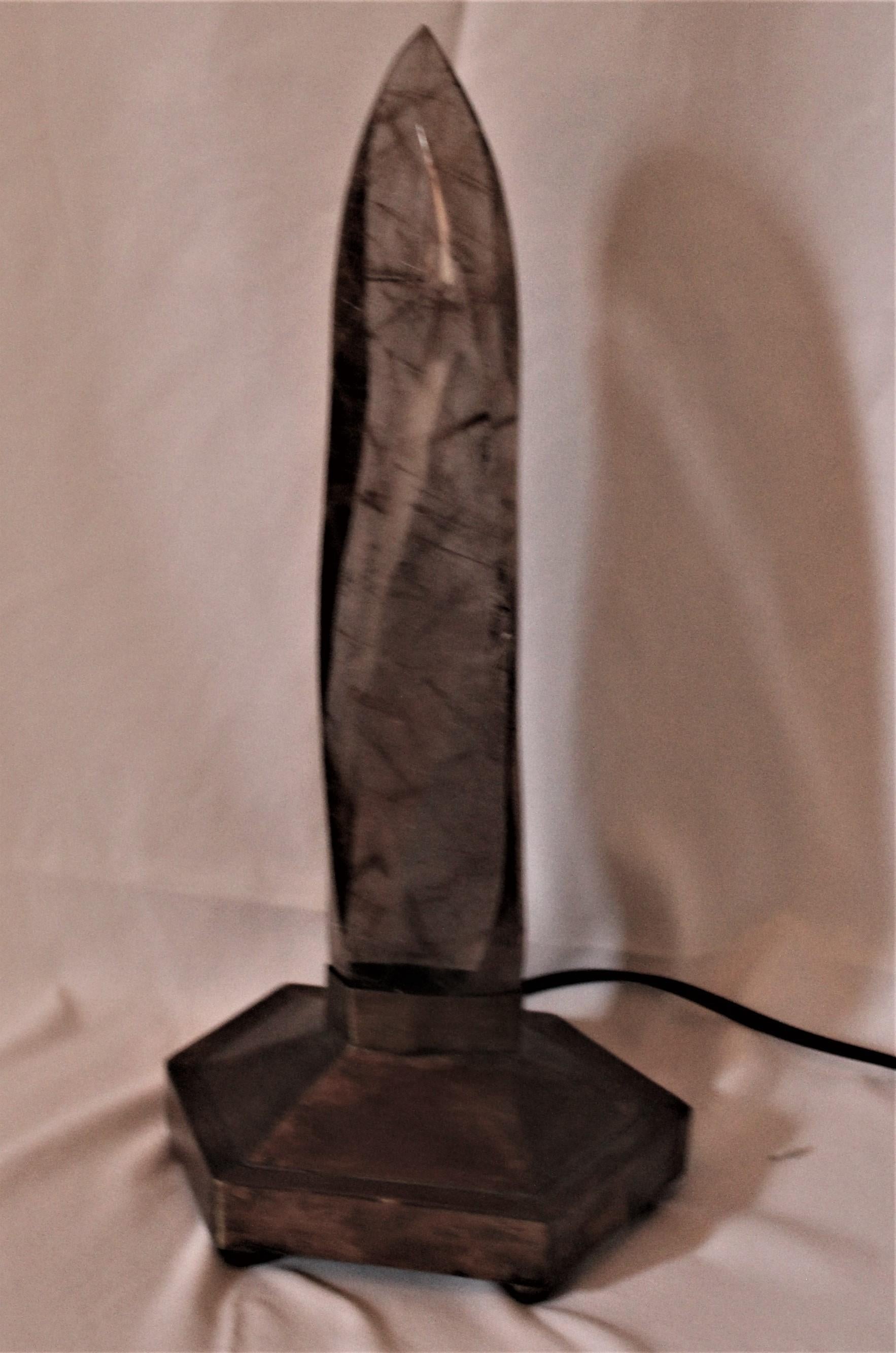 Grande punto di quarzo fumé con fili di rutilato, lucidato a specchio e realizzato con la luce delle baes in ottone esagonali personalizzate. Fantastico quando è illuminato. Pietra molto rara proveniente dal Brasile. E uno grande, con un'altezza di