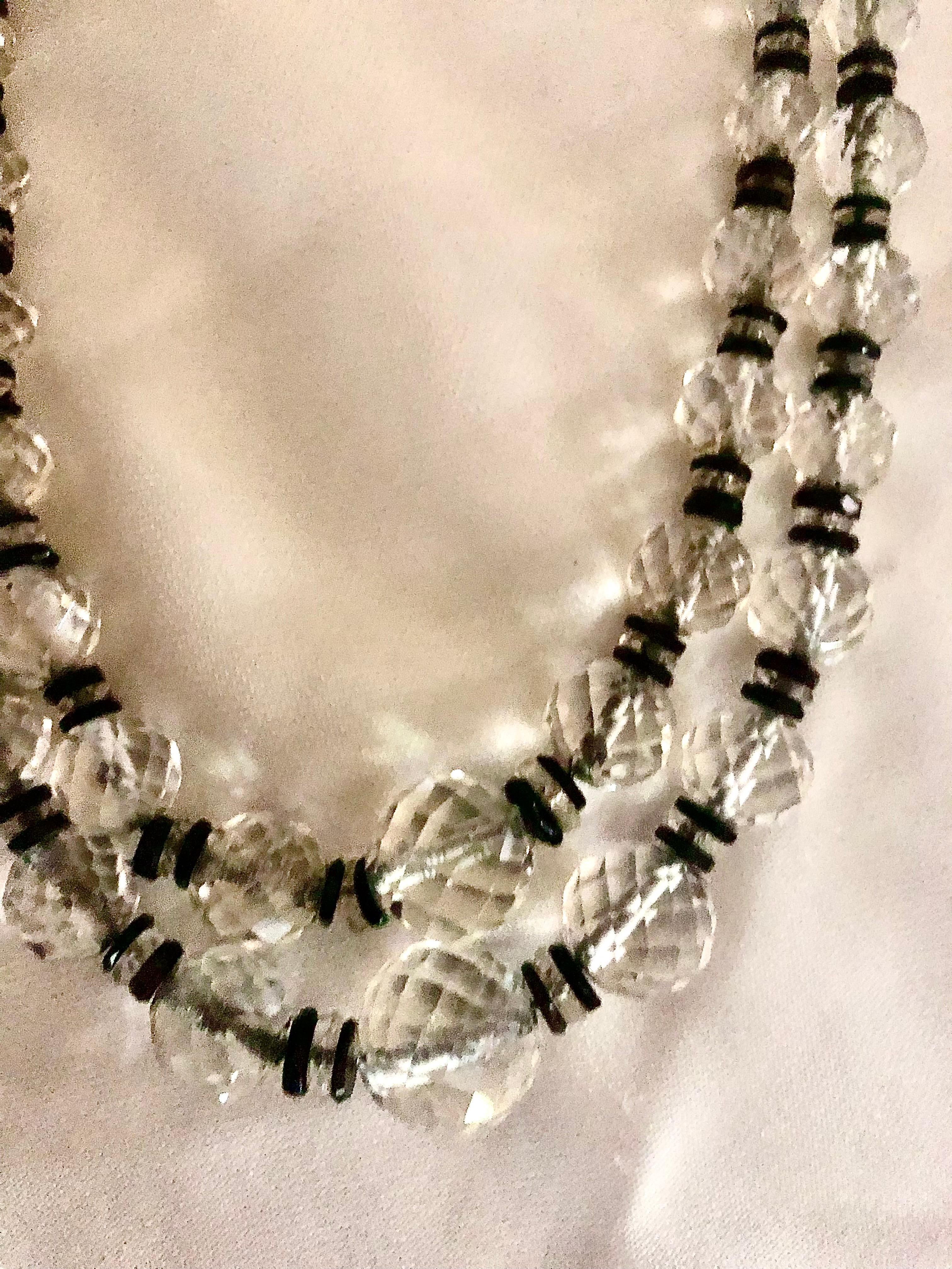 Il s'agit d'un ravissant collier à deux brins d'époque Art déco. La pièce est composée de perles de cristal de roche facettées et graduées. Ils alternent avec des rondelles de cristal facetté flanquées de disques d'onyx polis et lisses.

Les perles