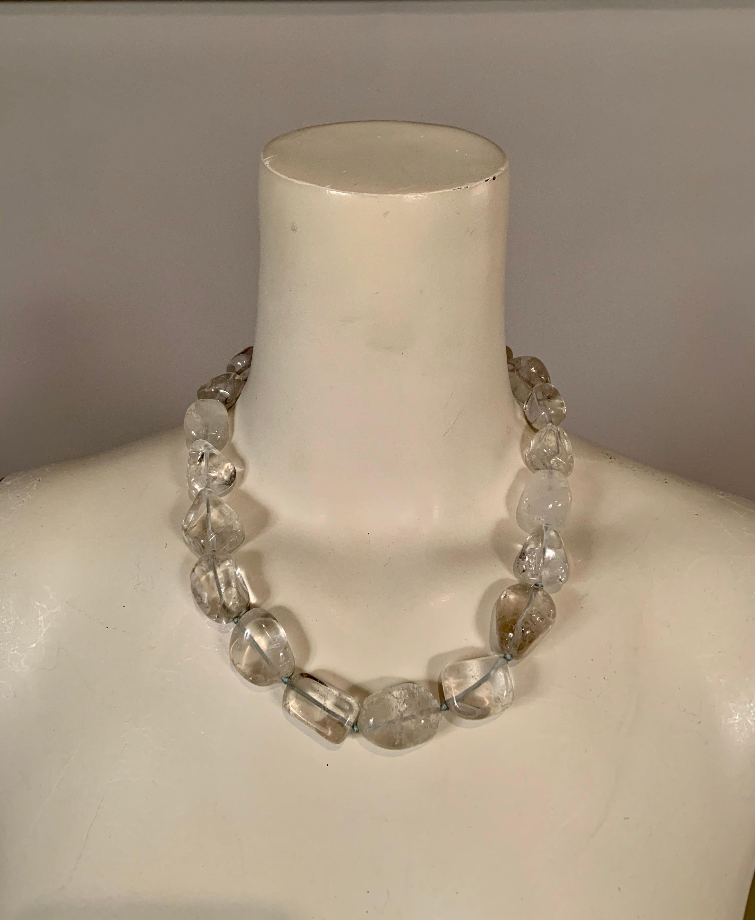 This chunky hand knotted rock crystal necklace is composed of 20 large beads with a smooth finish and irregular shapes for a one of a kind piece. It has a sterling clasp composed of two interlocking
rings on the same scale as the crystals. It is in