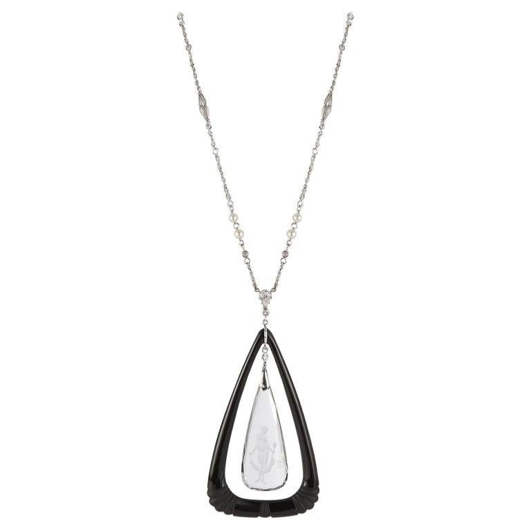 Collier avec pendentif en cristal de roche et onyx

Un pendentif en cristal de roche sculpté avec un motif d'angle entouré d'un cadre en onyx sculpté sur un collier en chaîne de diamants et de perles.

Mesures : 26