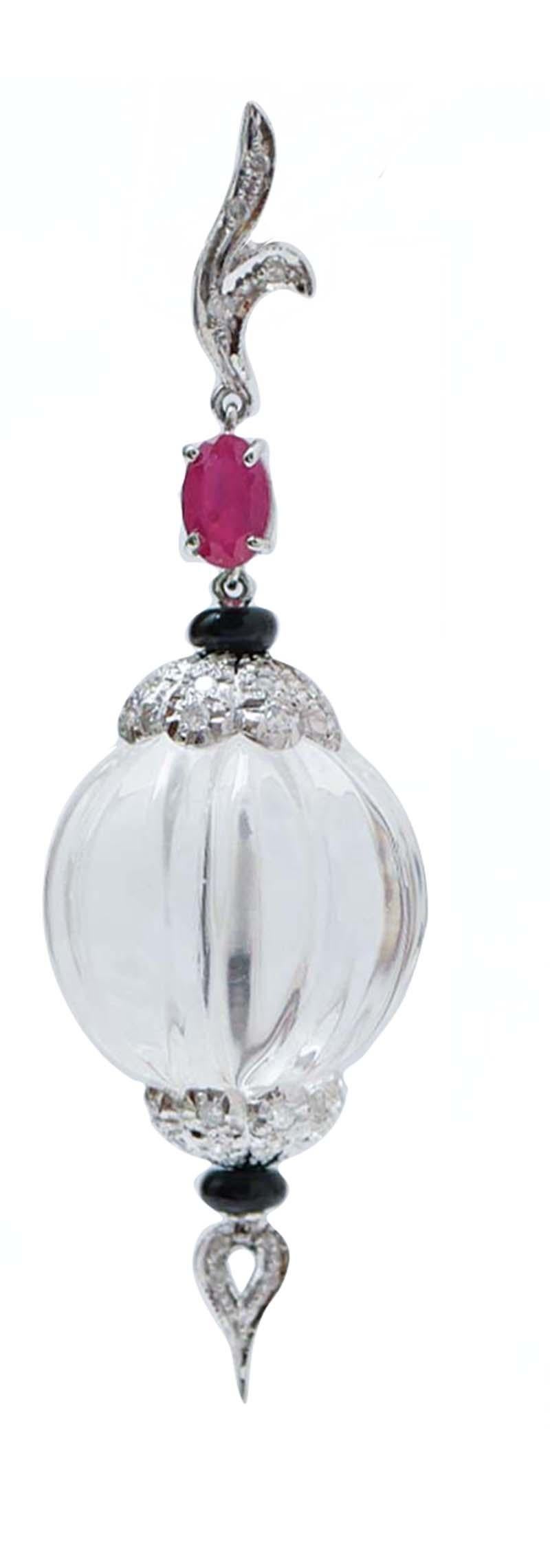 Amazing dangle earrings in 14 kt white gold structure mounted with diamonds and ruby in the upper part. In the middle, a sphere of rock crystal (  18 mm) between two structure studded with diamonds  and, below, an onyx and a drop pf diamonds.
These