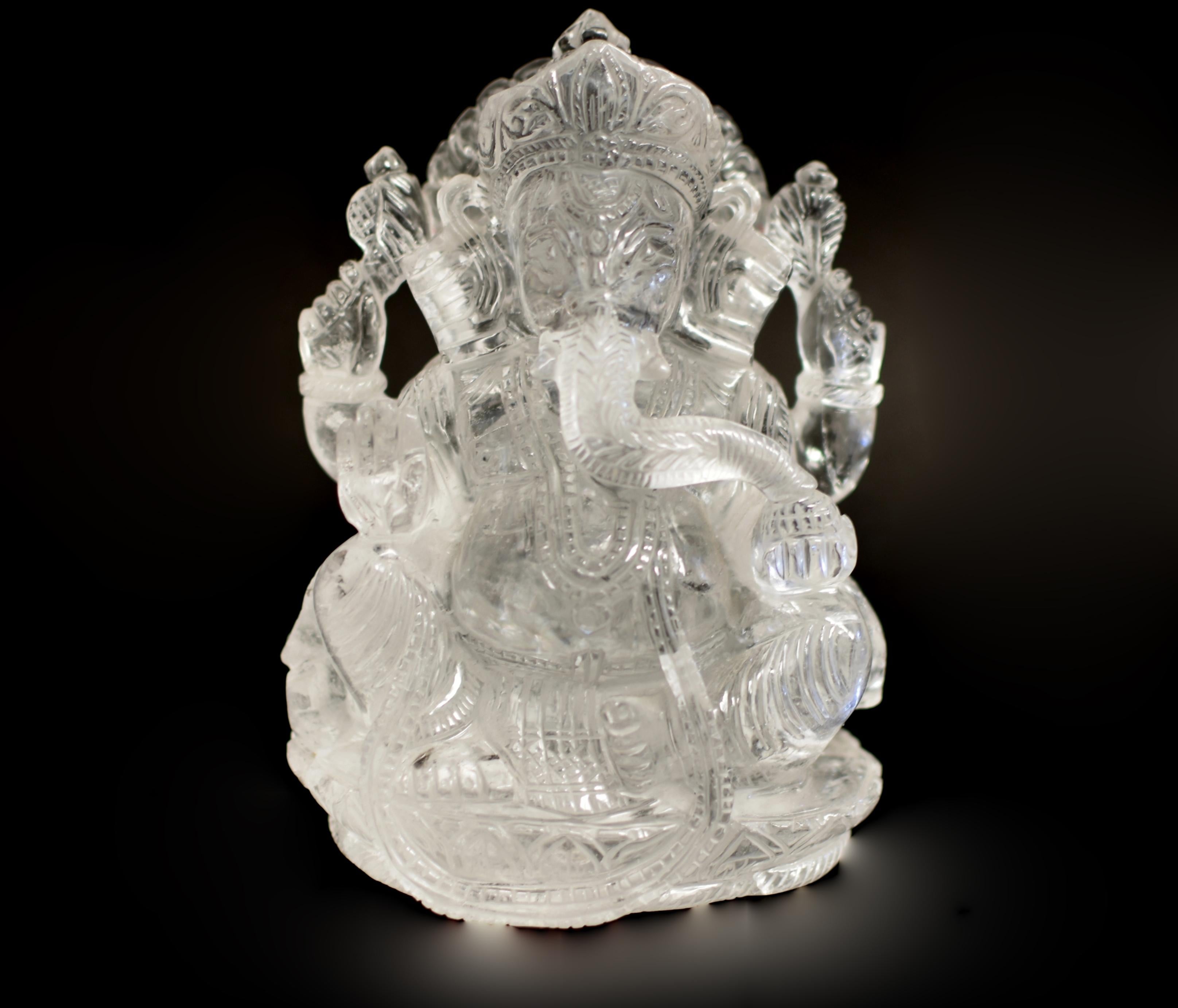 Une remarquable sculpture de Ganesha en quartz de cristal de roche massif de 5 livres. Assis sur un trône de lotus et soutenu par une mandorle rayonnante, Ganesh tient un bol de bonbons dans sa main gauche, symbolisant l'abondance et la générosité.