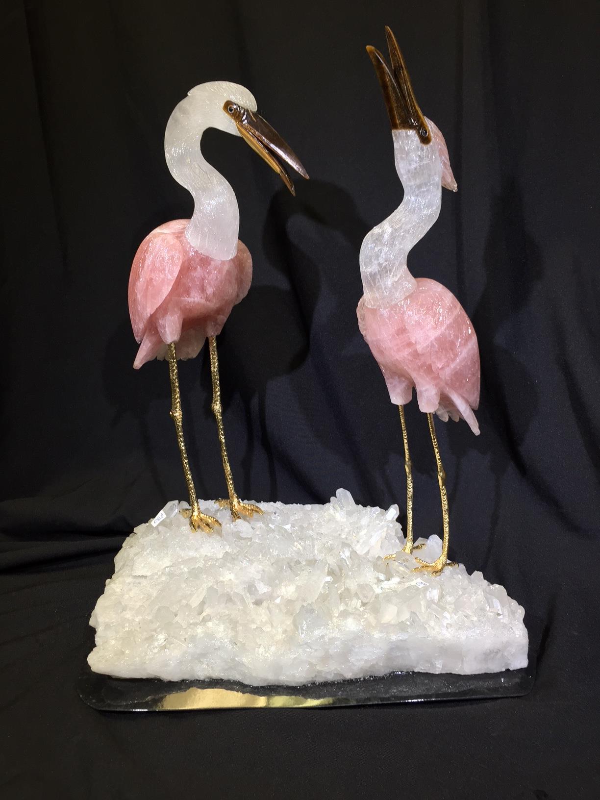 Impressive and finely hand carved and polished rock crystal, rose quartz and tiger eye large flamingo group resting on gilt bronze legs on a rock crystal cluster base.

