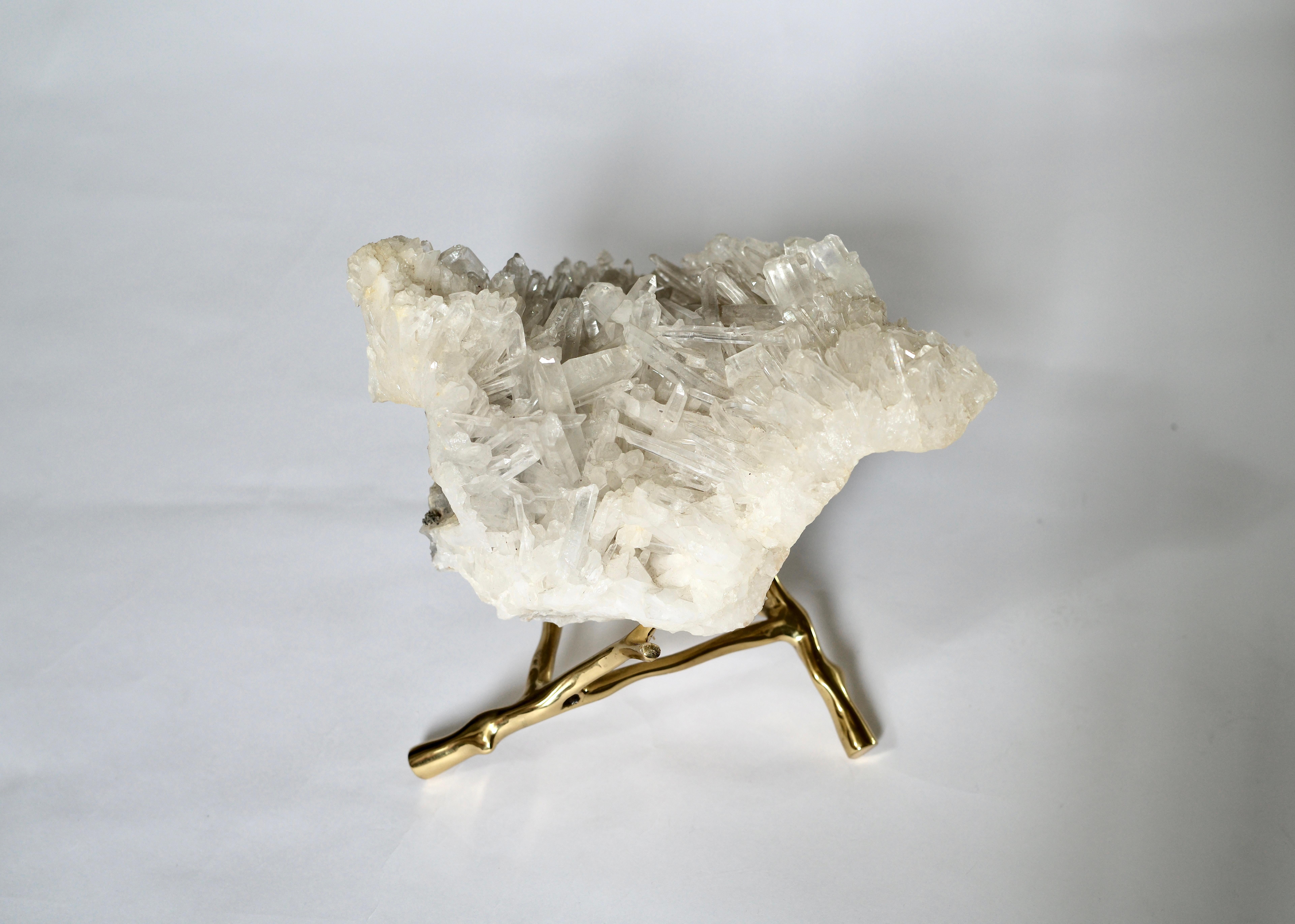 Natural rock crystal cluster sculpture with brass stand.