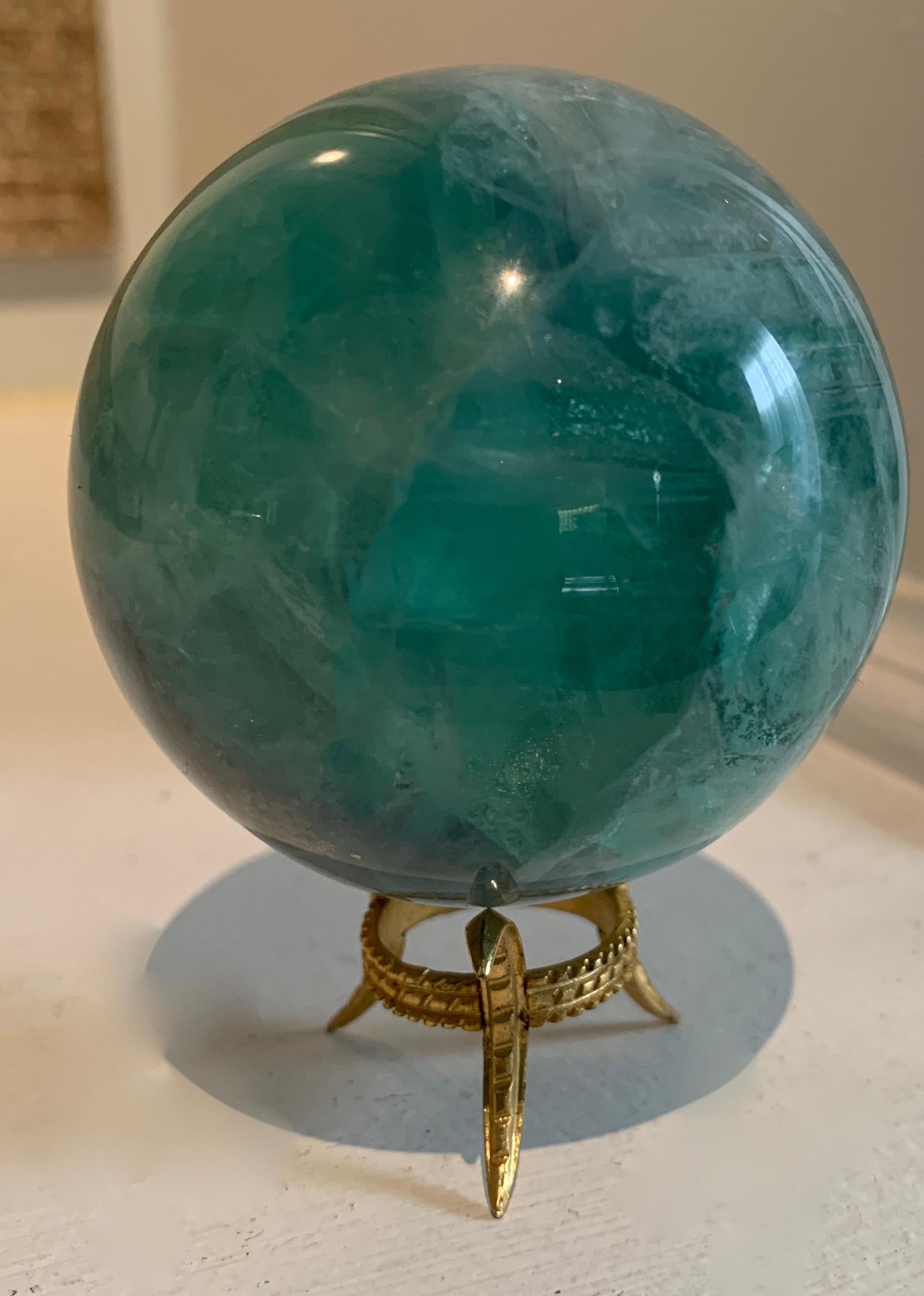 Rock crystal sphere on gold three pronged stand... a very elegant gift.

A compliment to any shelf or desk and wonderful as a sophisticated paper weight. The green rock crystal is a very peering and lovely specimen
