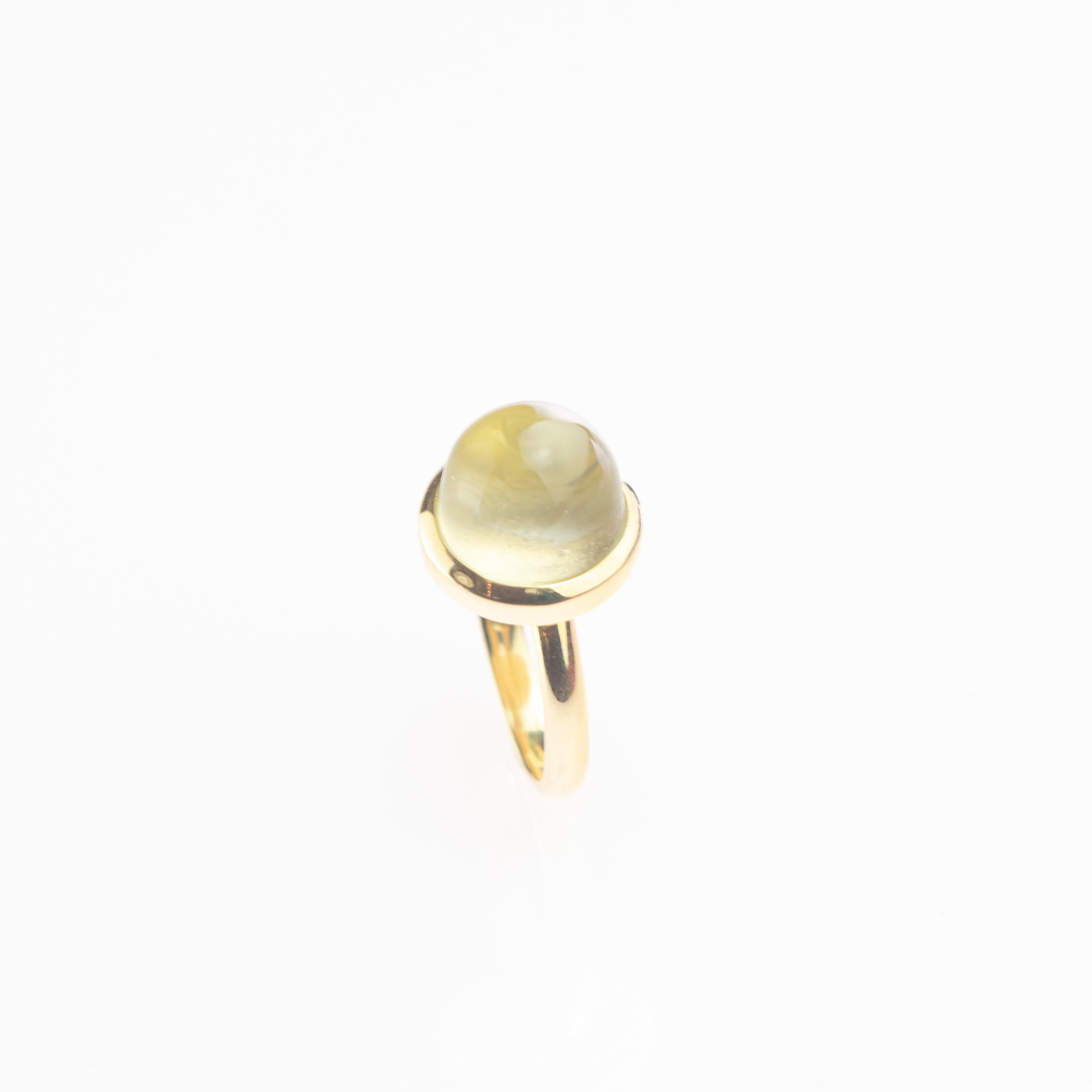 Rock crystal band cocktail ring. A a bright jewel with a minimalist design that enhances a matte pulish precious natural rock crystal  round stepped cabochon. The 18 karat yellow gold ring highlights the natural and sparkling color, surrounding into