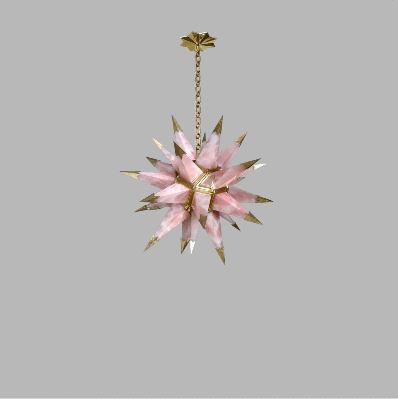 Pink rock crystal star chandelier with polish brass tips. Created by Phoenix Gallery, NYC.
Two candlelabra socket installed. Use two 75 watts LED candelabra lightbulbs.
The chandelier is 21.5”/W x 21.5”/D x 21.5”/H without the chain.

Light bulb