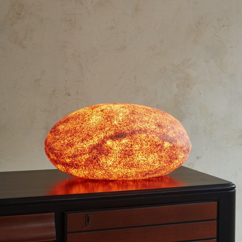 A 1960s rock lamp attributed to Andre Cazenave (1928-2003). This lamp was made from resin and marble powder and designed to emulate an oversized pebble. We love the textural finish and realistic detailing on this beauty. When lit, it emulates a warm
