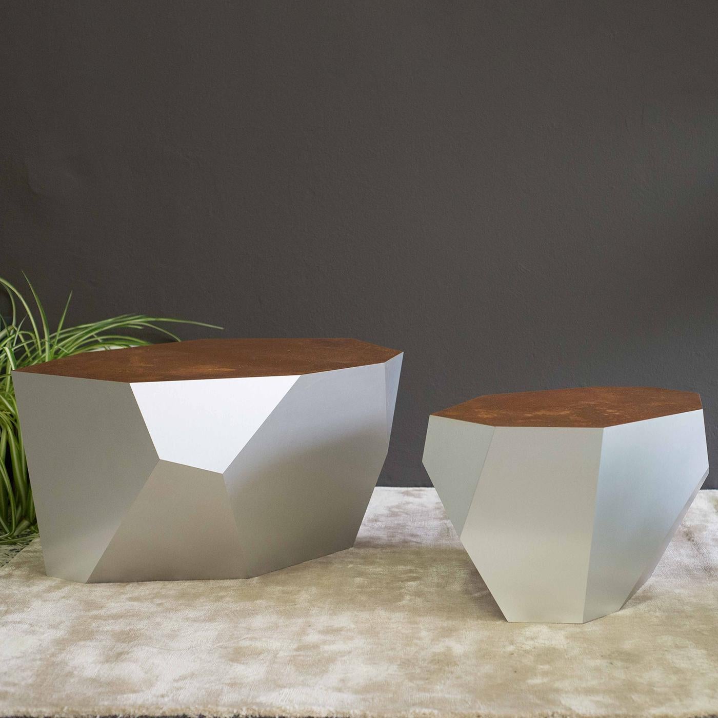 Part of the Rock series, this coffee table's original and stunning design features a form-folded aluminum base with a white anodized finish with a corten steel top, creating a distinctive, weathered appearance. This extraordinary piece will make a