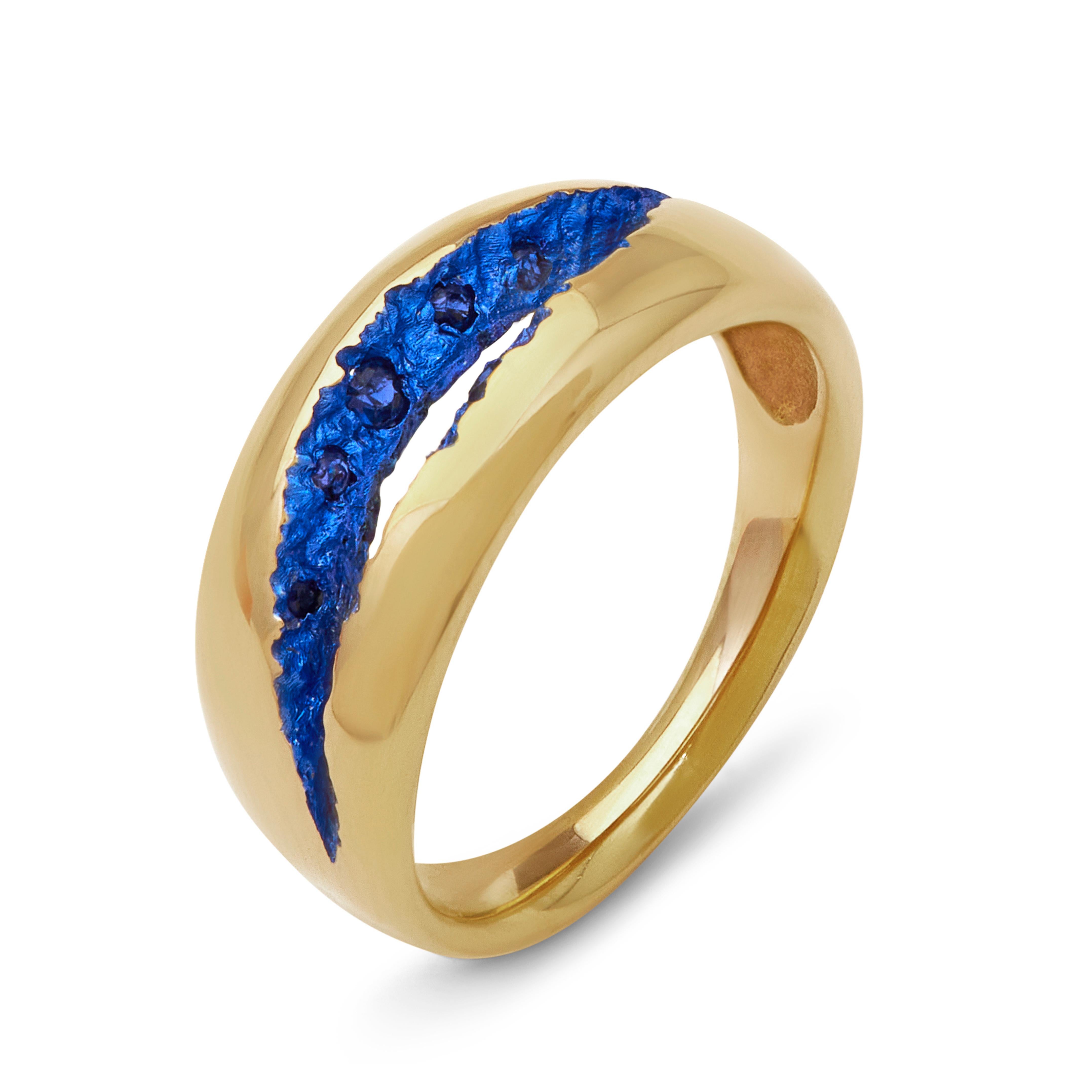 This wide band is a simple jewellery design focusing on the textures of the crevasse teamed with a sprinkling of blue sapphires for a contrasting sparkle peering out.  The overlay of blue ceramic plating is what truly sets it apart from other rings,