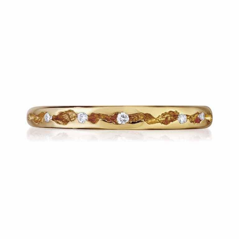 Dive into the enchanting world of rock pools with this whimsical diamond band. Imagine a ring adorned with a crevasse running along the top, where glimmering white diamonds peek out like eye-catching sea creatures. It captures the essence of mystery