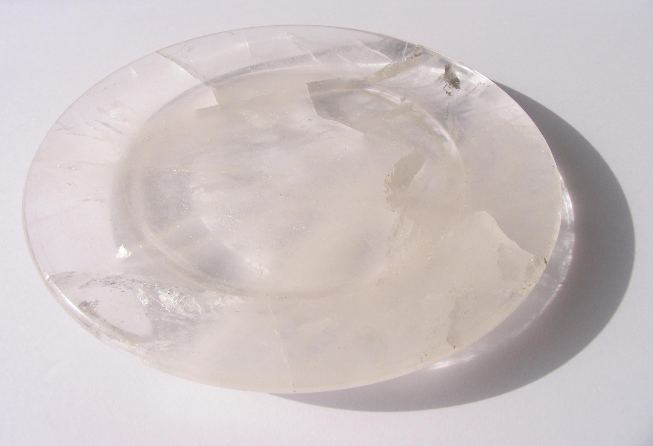 Rock crystal circular tray with wide rim and flat bottom.
 Hand carved from one piece of natural clear quartz crystal.