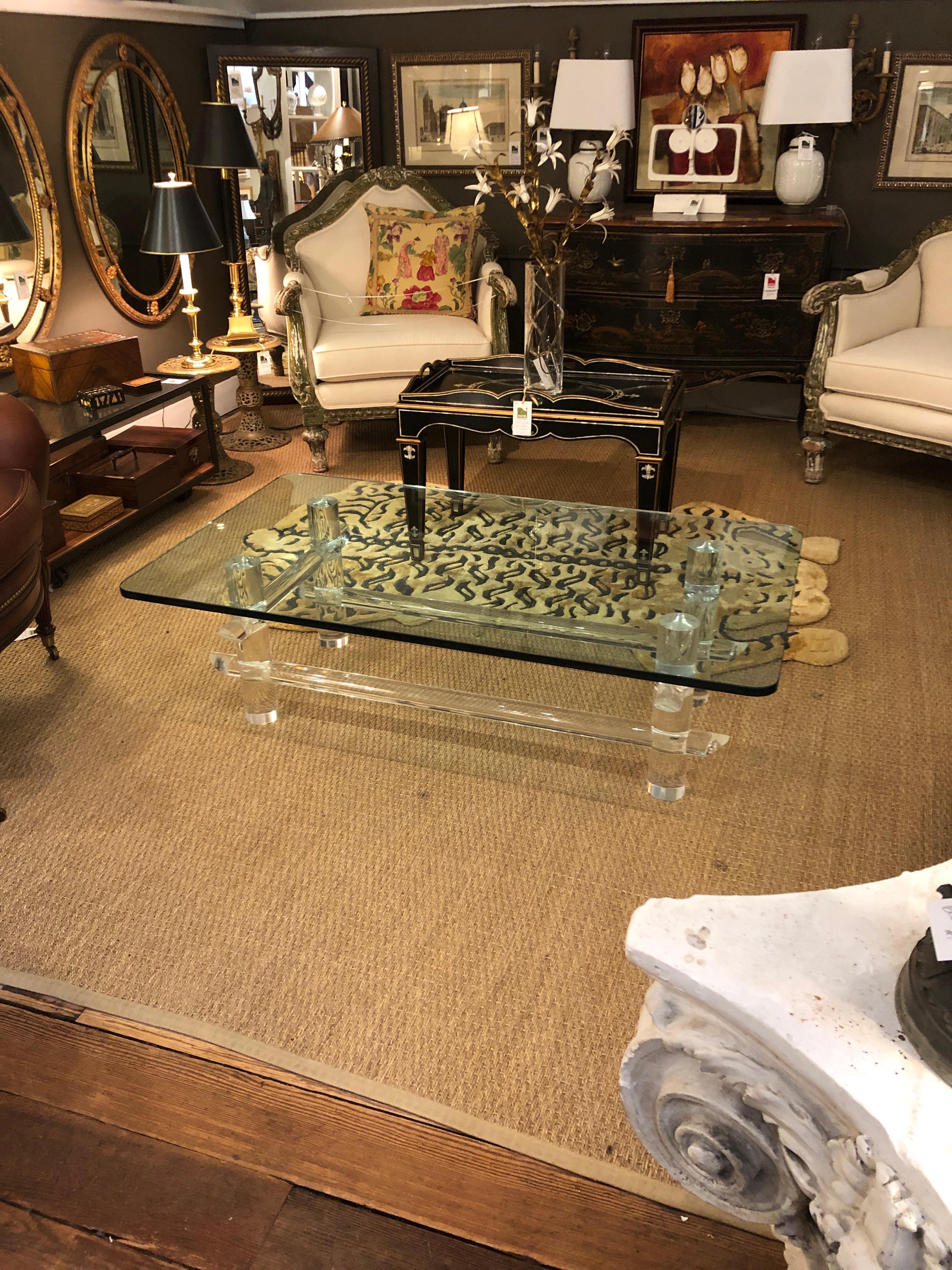 A rare form of a glitzy midcentury modern elegant Lucite and glass rectangular coffee table having chunky Lucite columnar shaped rods in a faux bamboo designed base and a super thick 3/4 inch glass top.