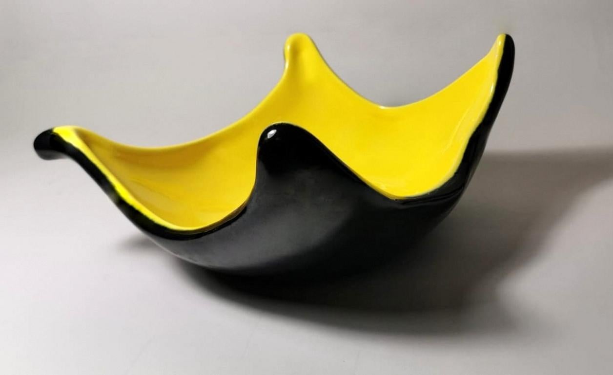 Yellow and black ceramic bowl in Rockabilly style; the colors are vigorous and strong; the very particular shape makes it capacious and comfortable; produced in northern Italy in 1952. The word 