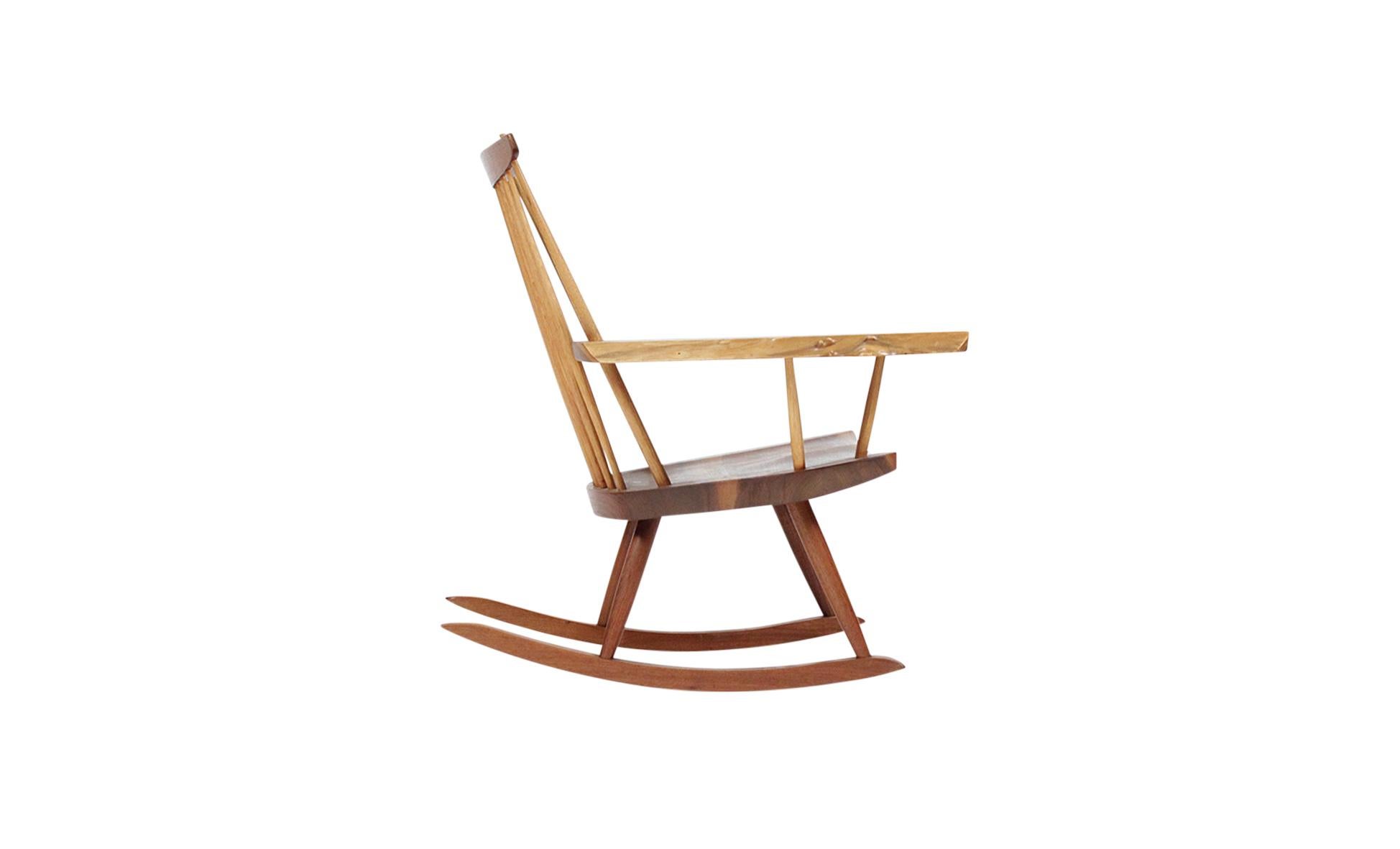 Iconic single arm rocker by George Nakashima. Executed in walnut with hickory spindles. Large expressive right arm. Chair is signed and dated and comes with complete provenance.
  