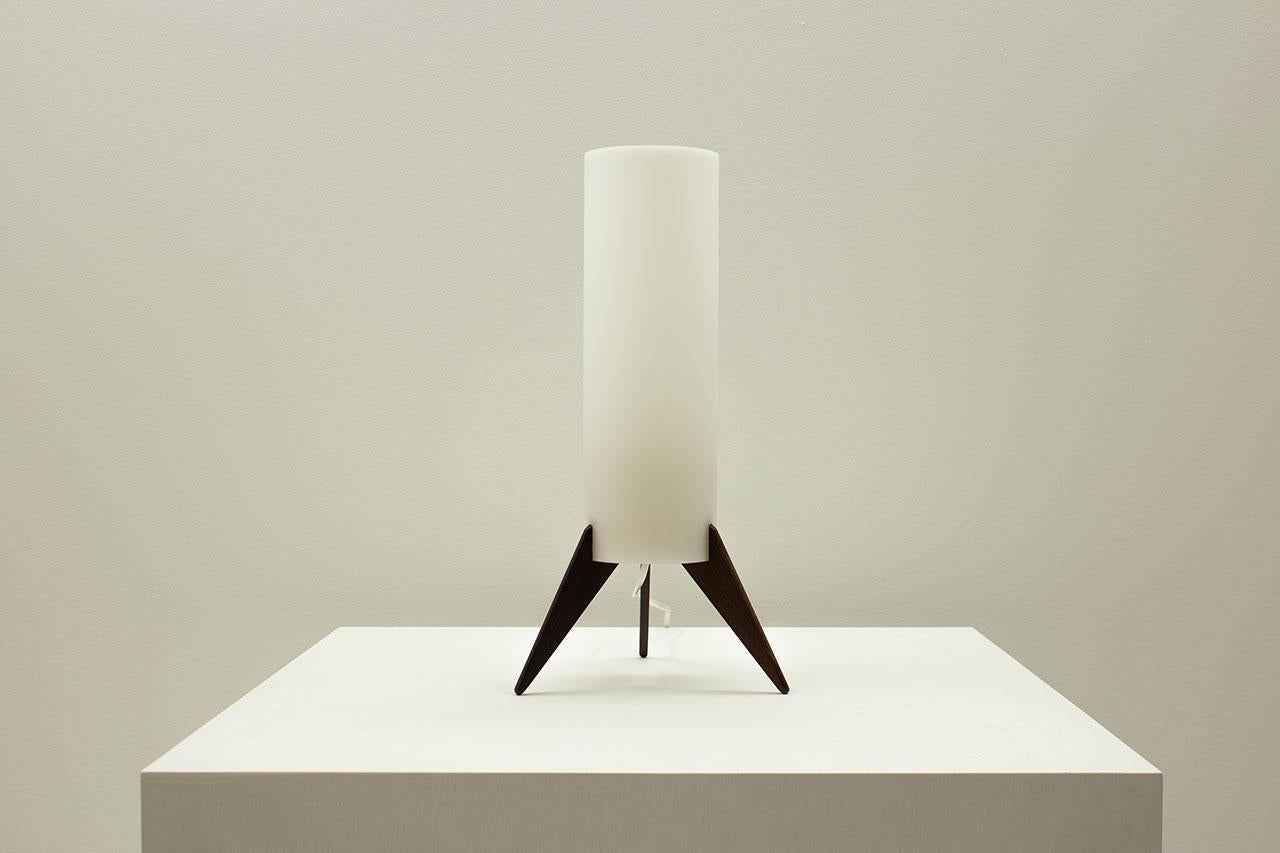 Lampe de table en forme de fusée, modèle B129, conçue par Unö & Östen Kristiansson pour leur propre société Luxus. Fabriqué à Vittsjö en Suède dans les années 1960. La lampe est composée d'une base en bois foncé et d'un diffuseur en acrylique. Le