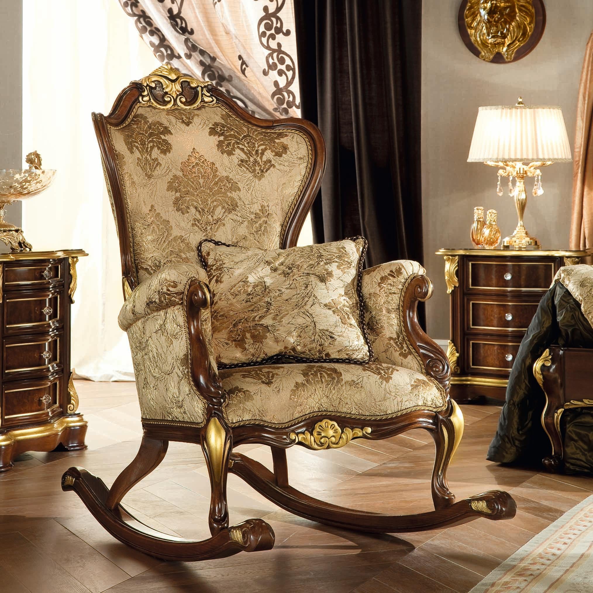 Fauteuil à bascule baroque de grande classe en bois de noyer naturel et finitions en feuilles d'or patinées. Rembourré avec un tissu ivoire damassé de première qualité et testé par nos employés spécialisés. Chaque détail est sculpté à la main par