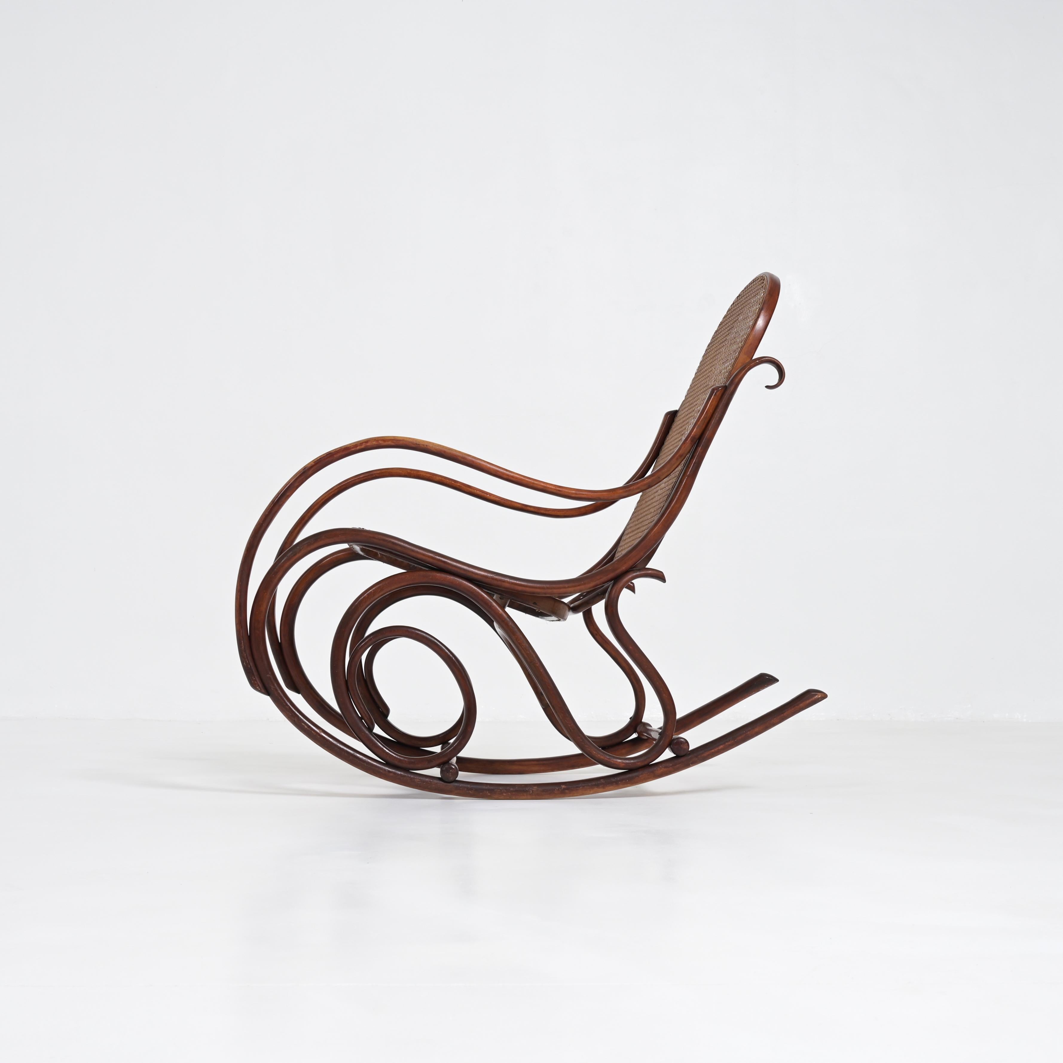 Ce vieux fauteuil à bascule authentique a été conçu par Michael Thonet et fabriqué par Thonet. Il figurait dans le catalogue de 1904. C'est un classique du design.
Ce fauteuil à bascule marron est en très bon état vintage avec des signes normaux