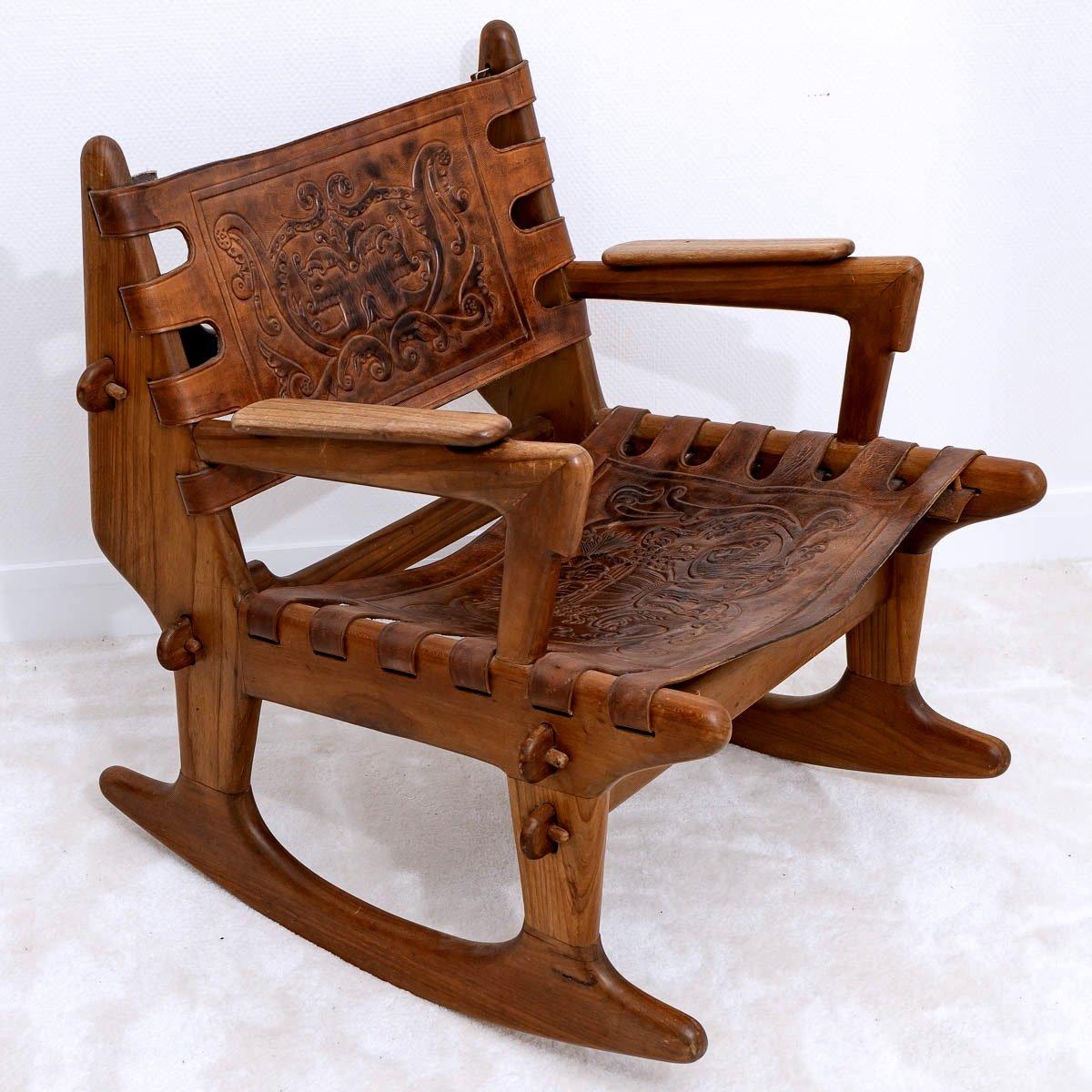  A beautiful Rocking Chair, Laurel's solid wood frames, which fit together and are held together by simple pegs, add a constructivist touch. 
The handcrafted leather slings, forming the seat and backrest, refer to the particular culture of Ecuador's