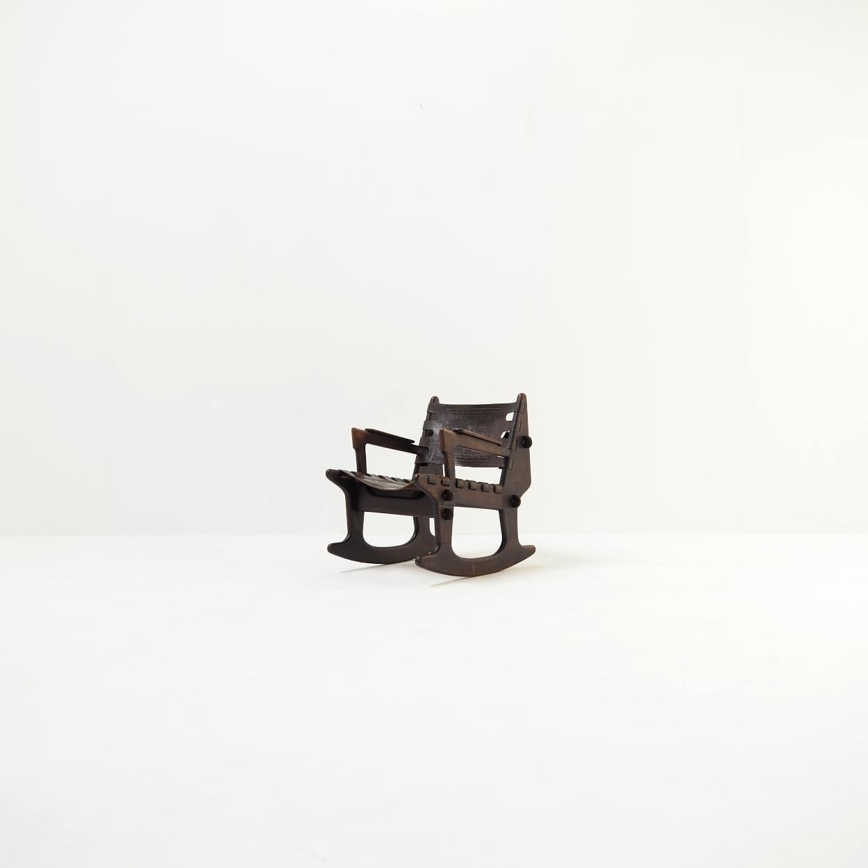Very decorative and functional rocking chair, designed by Angel Pazmiño for the Ecuadorian manufacturer Muebles De Estilo.

The chair has a beautifully patinated wooden frame with a dark color. The leather is also beautifully patinated and in very