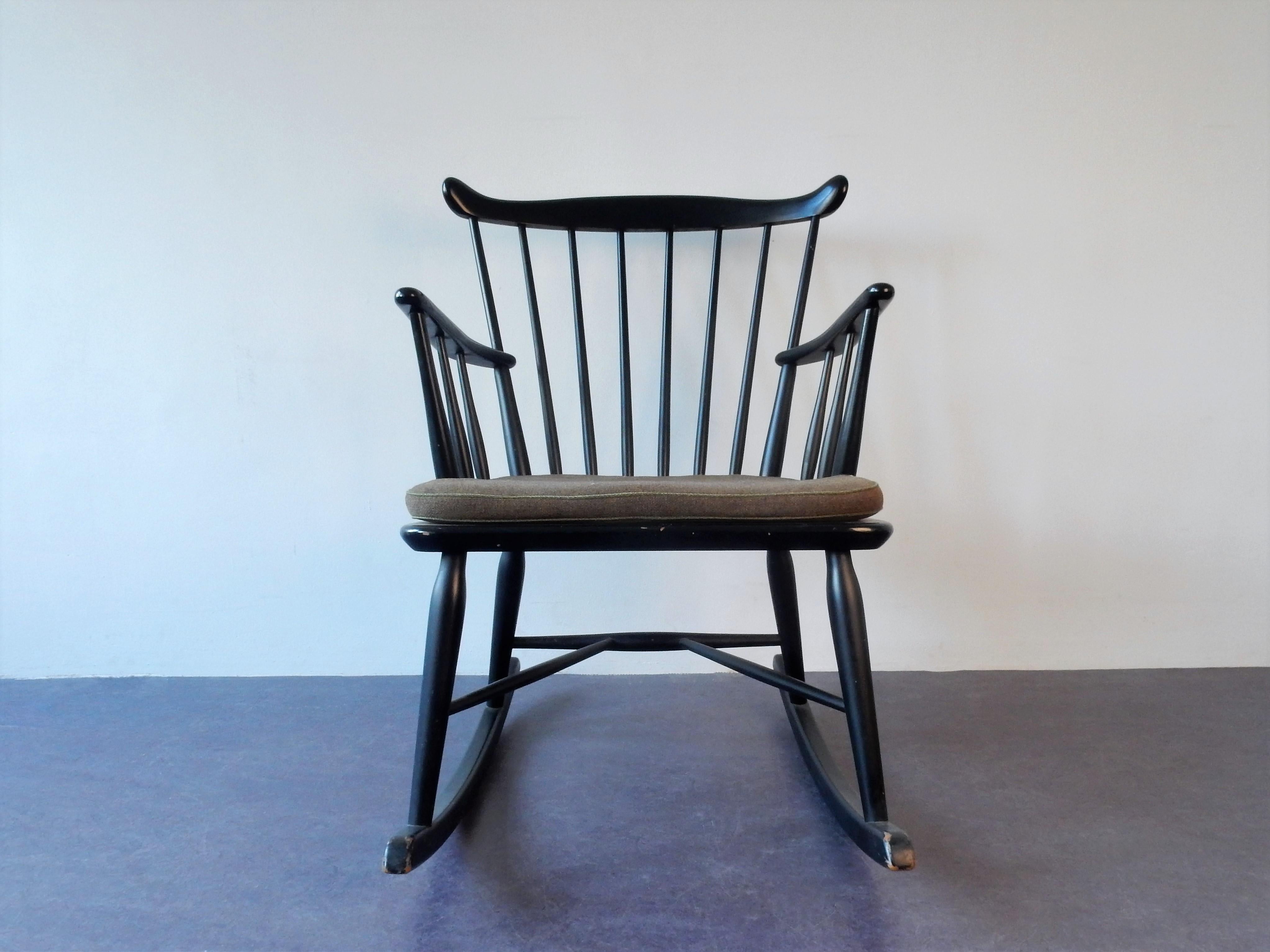 This is a very nice black lacquered spindle back rocking chair from Farstrup Mobler, Denmark. It comes with a cushion that does show signs of age and use and this could be replaced for a newly upholstered cushion. This chair is in a very good