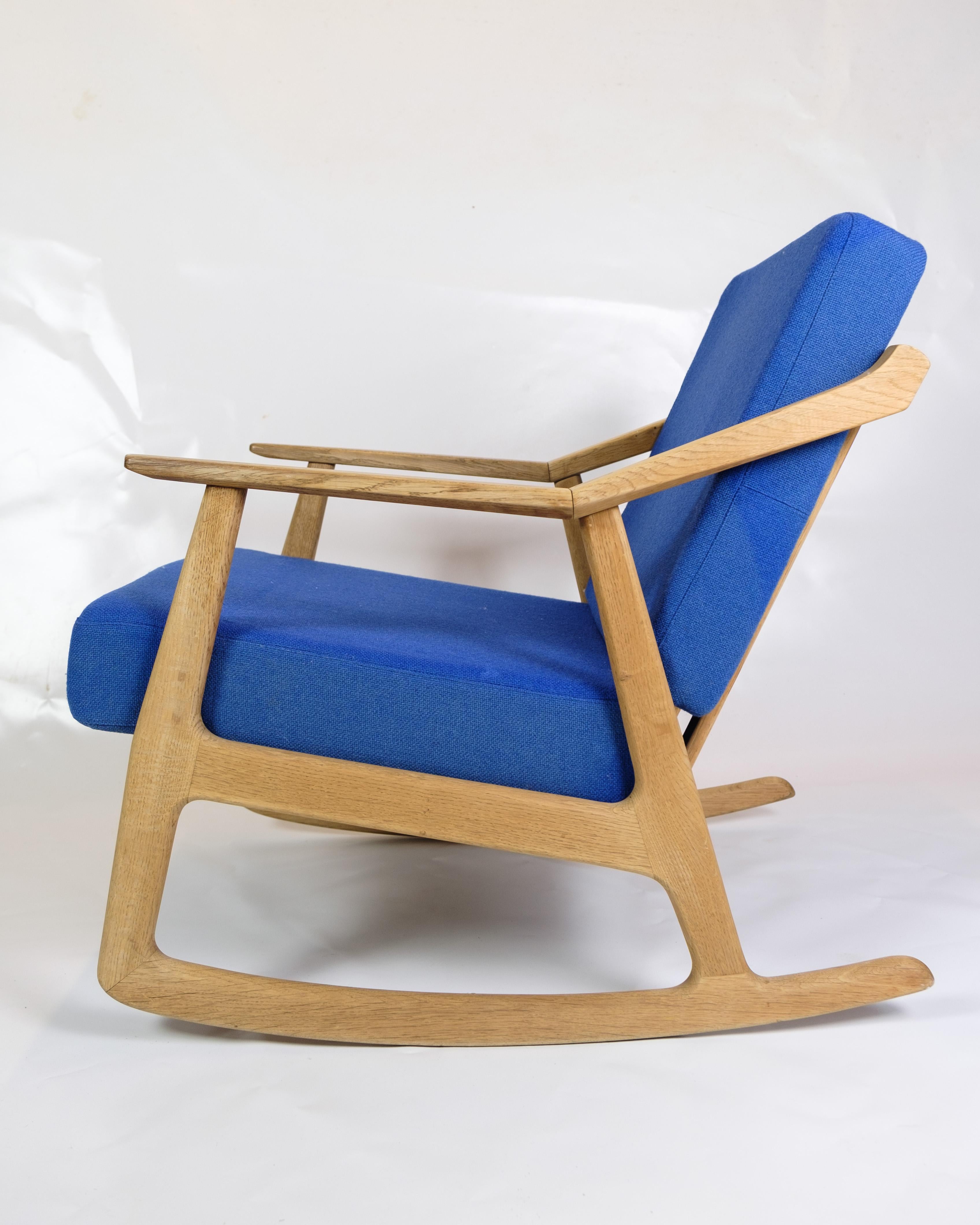 1960s Oak Rocking Chair Designed by H. Brockmann-Petersen, Upholstered in Blue Fabric by Randers Møbelfabrik

Indulge in the timeless comfort of this rocking chair, a design attributed to H. Brockmann-Petersen and meticulously crafted in oak by