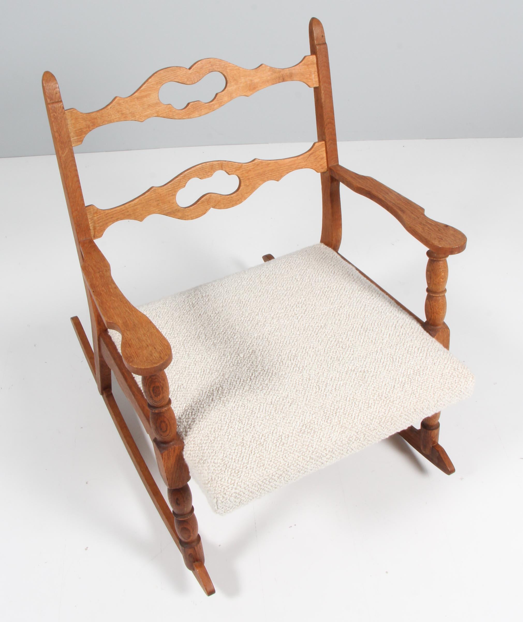 Rocking chair by Henning Kjærnulf, made of oak and new upholstered with boucle fabric. 

Refreshing design with bold Baroque coming together nicely with midcentury modernism.

Model: Razorblade

Made by EG møbler in the 1960s-1970s.
  