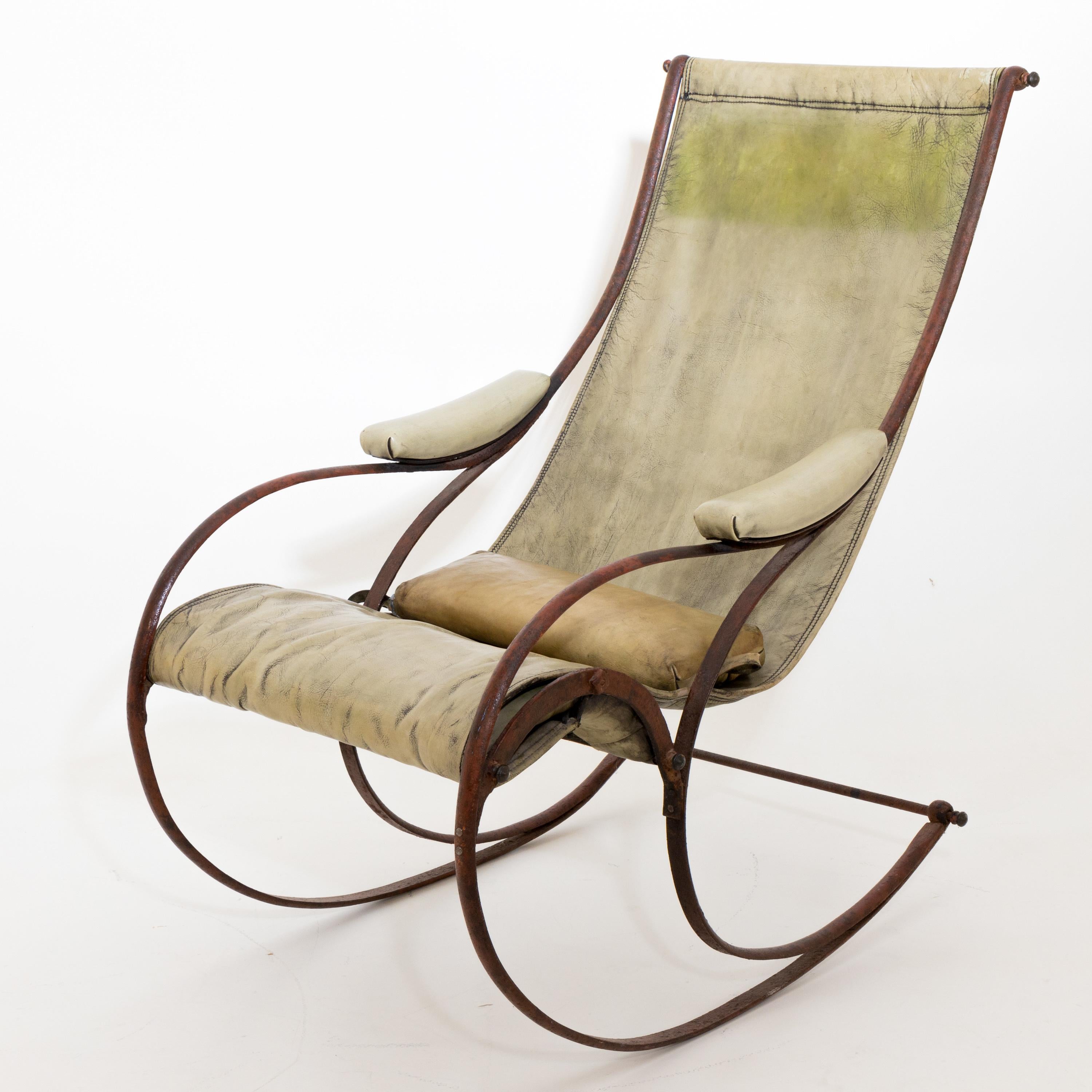 English rocking chair with leather upholstery on curved iron frame.