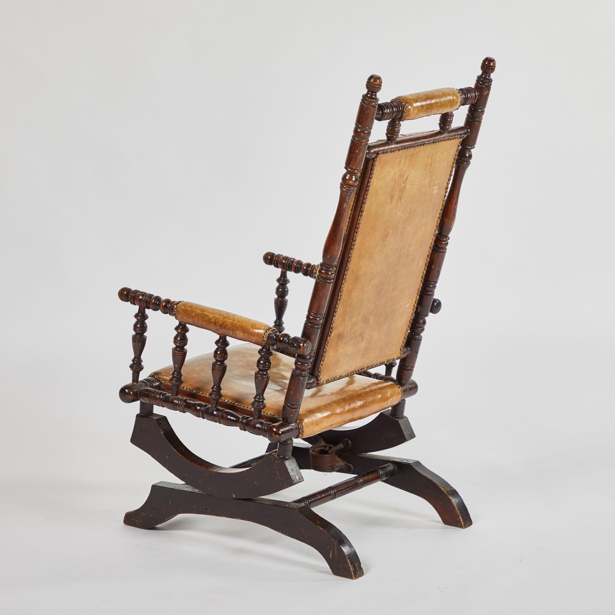 Victorian mahogany rocking chair with tufted honey-toned leather upholstery. Mounted on a platform base and with fabulous turned wood detailing, the design has a cozy, Neo-Gothic feel. 

England, circa 1880

Dimensions: 21W x 25.5D x 41.5H
