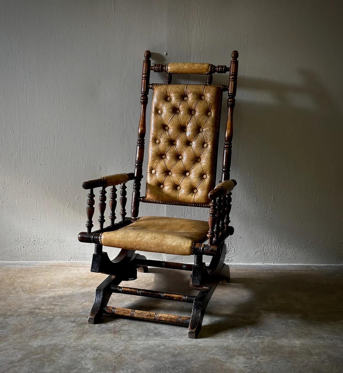 Questa sedia a dondolo vittoriana in mogano vanta un'imbottitura in pelle color miele, che emana un'aura di eleganza tradizionale. Montato su una maestosa base a piattaforma con squisiti dettagli in legno tornito, incarna un fascino accogliente e
