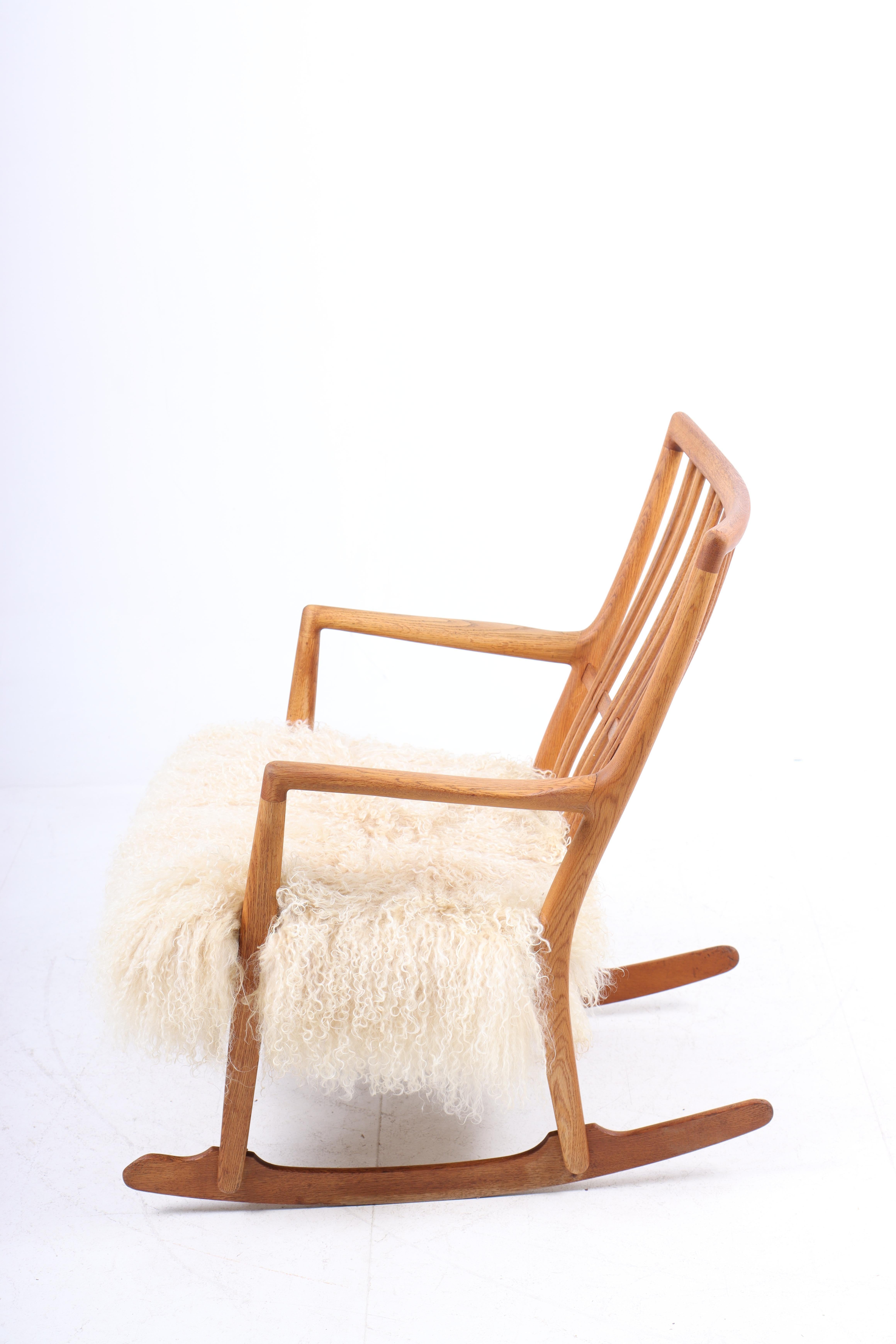 Rocking chair in oak and sheepskin, designed by Hans Wegner and made by Mikael Laursen. Great condition.