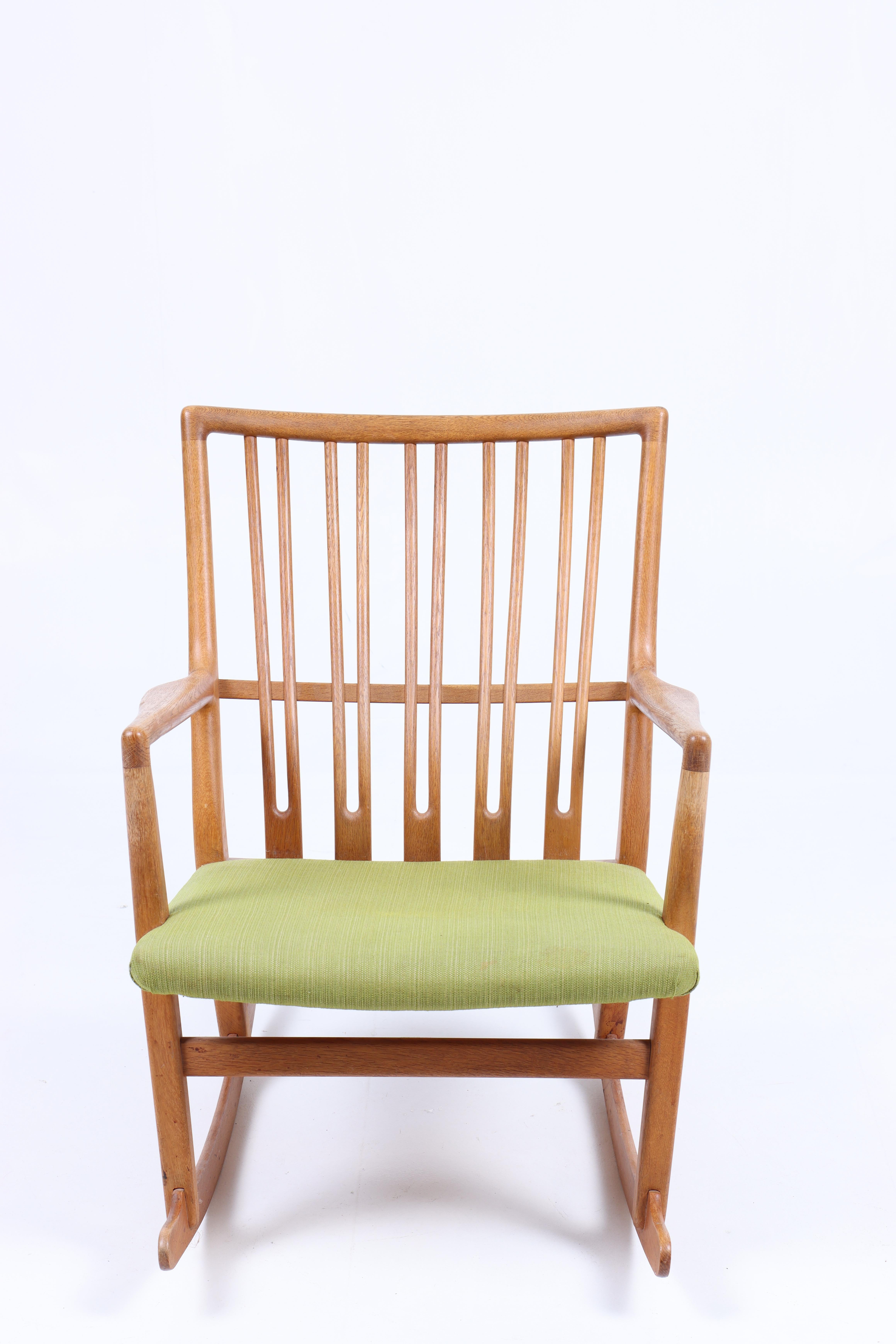 Sedia a dondolo in Oak e tessuto, disegnata da Hans Wegner e realizzata da A. Mikael Laursen. Ottime condizioni.