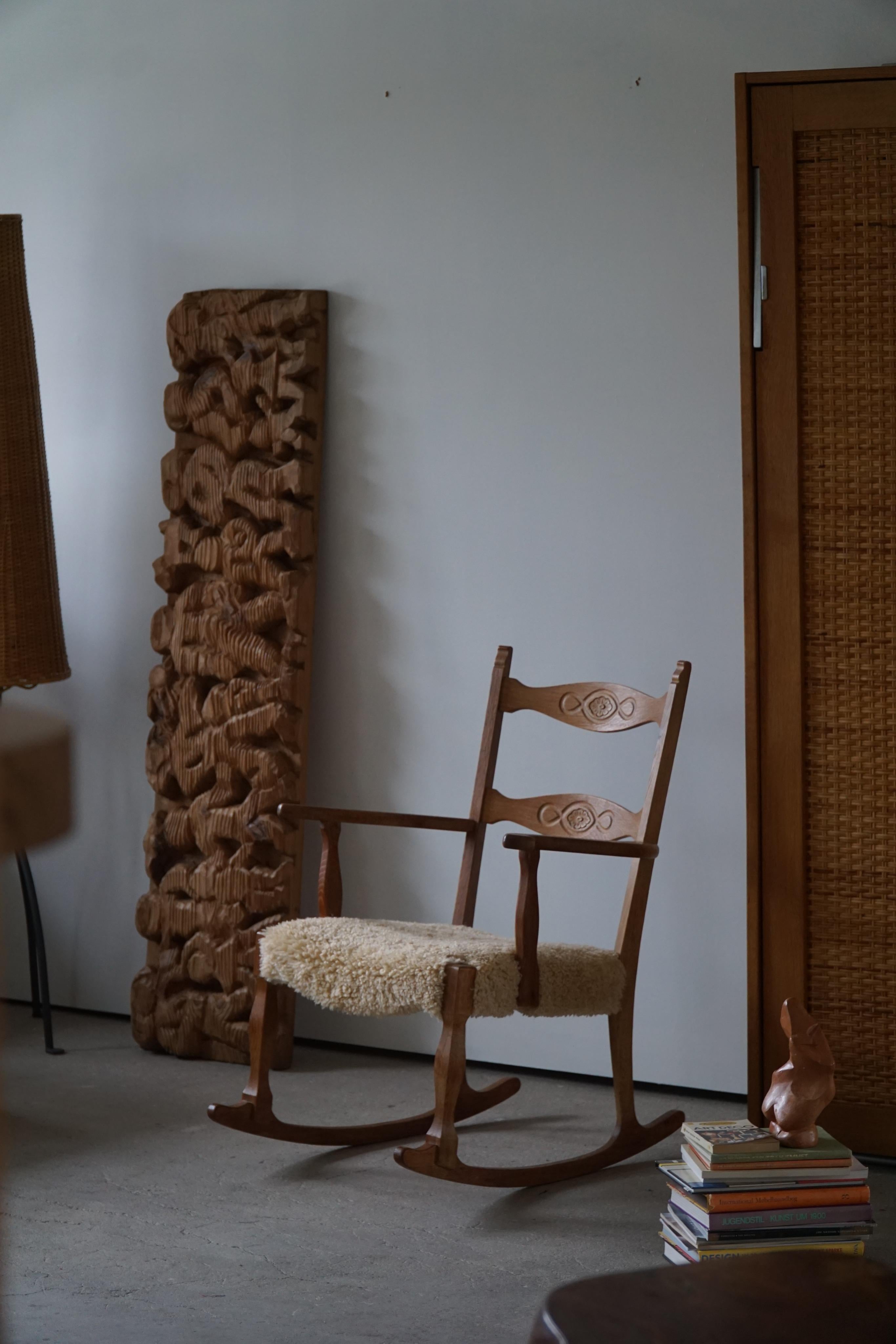 Lovely rocking chair in solid oak, seat reupholstered in lambswool. Designed by Henning (Henry) Kjaernulf for Nyrup Møbelfabrik, Denmark, 1960s.

This decadent rocking chair will complement many interior styles. A modern, antique, classic,
