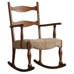 Chaise à bascule en chêne, assise rembourrée en laine d'agneau, Henning Kjærnulf, années 1960