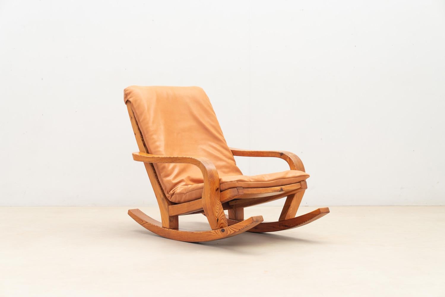 Retournez dans la France des années 1970 avec cette chaise à bascule. Solidement construit en pin, il est recouvert d'un coussin en cuir neuf de haute qualité.

N'hésitez pas à nous contacter pour toute information complémentaire. Nous nous ferons