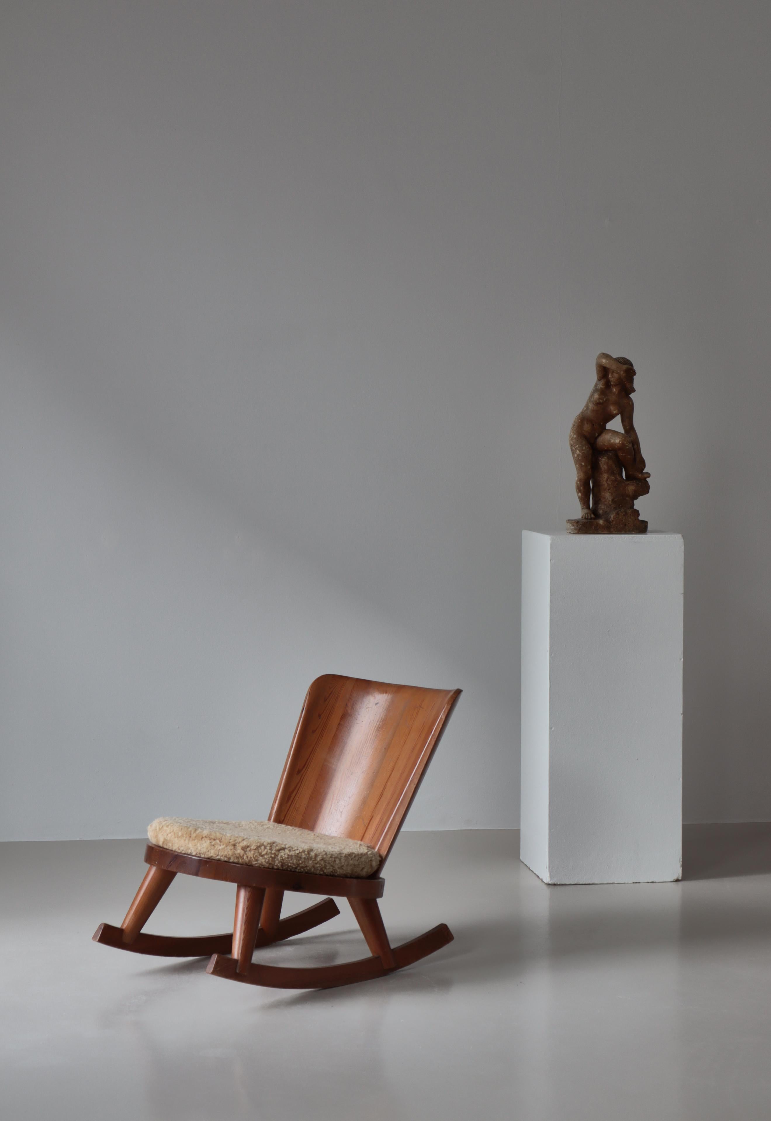 Rare fauteuil à bascule conçu par Göran Malmvall dans les années 1930 et fabriqué en Suède par Svensk Hemslöjd. Fabriqué en bois de pin scandinave massif avec une belle patine. La chaise est en bon état et le coussin d'origine a été retapissé en