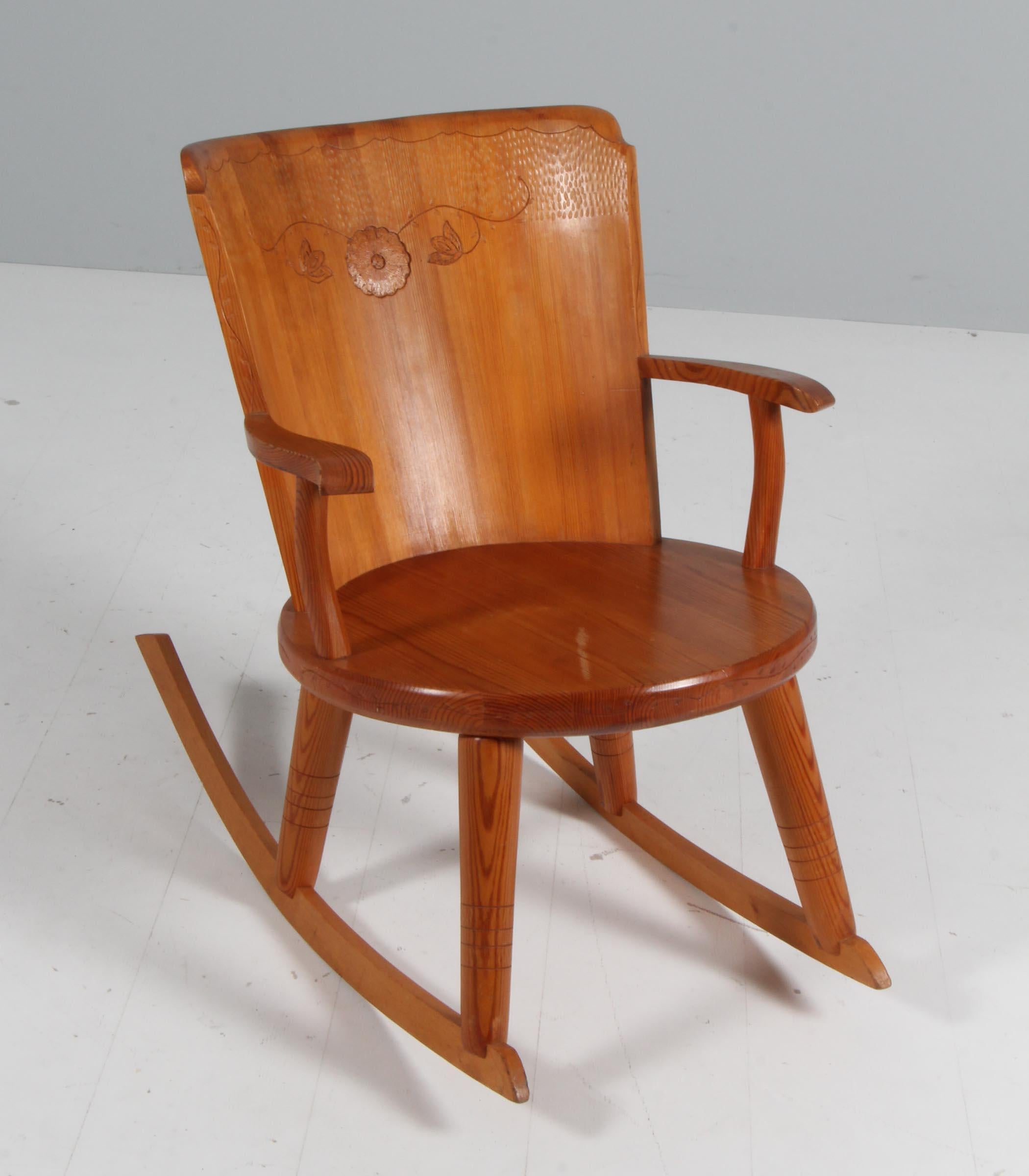 Rocking chair made of solid pine, with carved details.

Made in Sweden in the 1970s