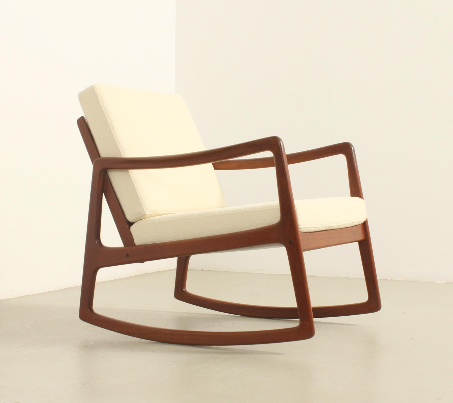 Sedia a dondolo modello 120 disegnata nel 1951 da Ole Wanscher per France & Son, Danimarca.
Struttura in legno massiccio di teak con cuscini con nuova schiuma e nuova imbottitura in tessuto bouclé. Firmato con il logo France & Son.