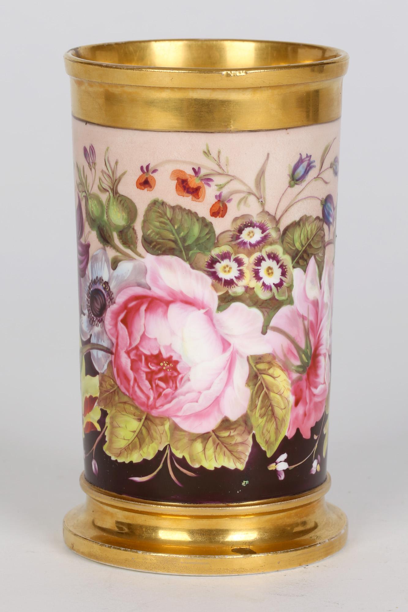 A stunning and exquisitely hand painted antique Rockingham porcelain vase decorated with floral blooms dating from around 1830. The finely made vase is of cylindrical shape with a wider stepped base and is hand painted with a continuous band of