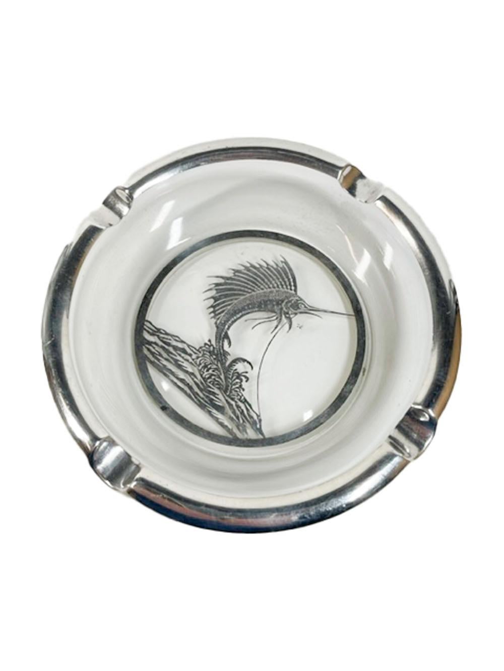 Silver overlay ashtray by Rockwell Silver Company with a silver overlay four divot rim centering a hooked leaping marlin / sailfish over waves.