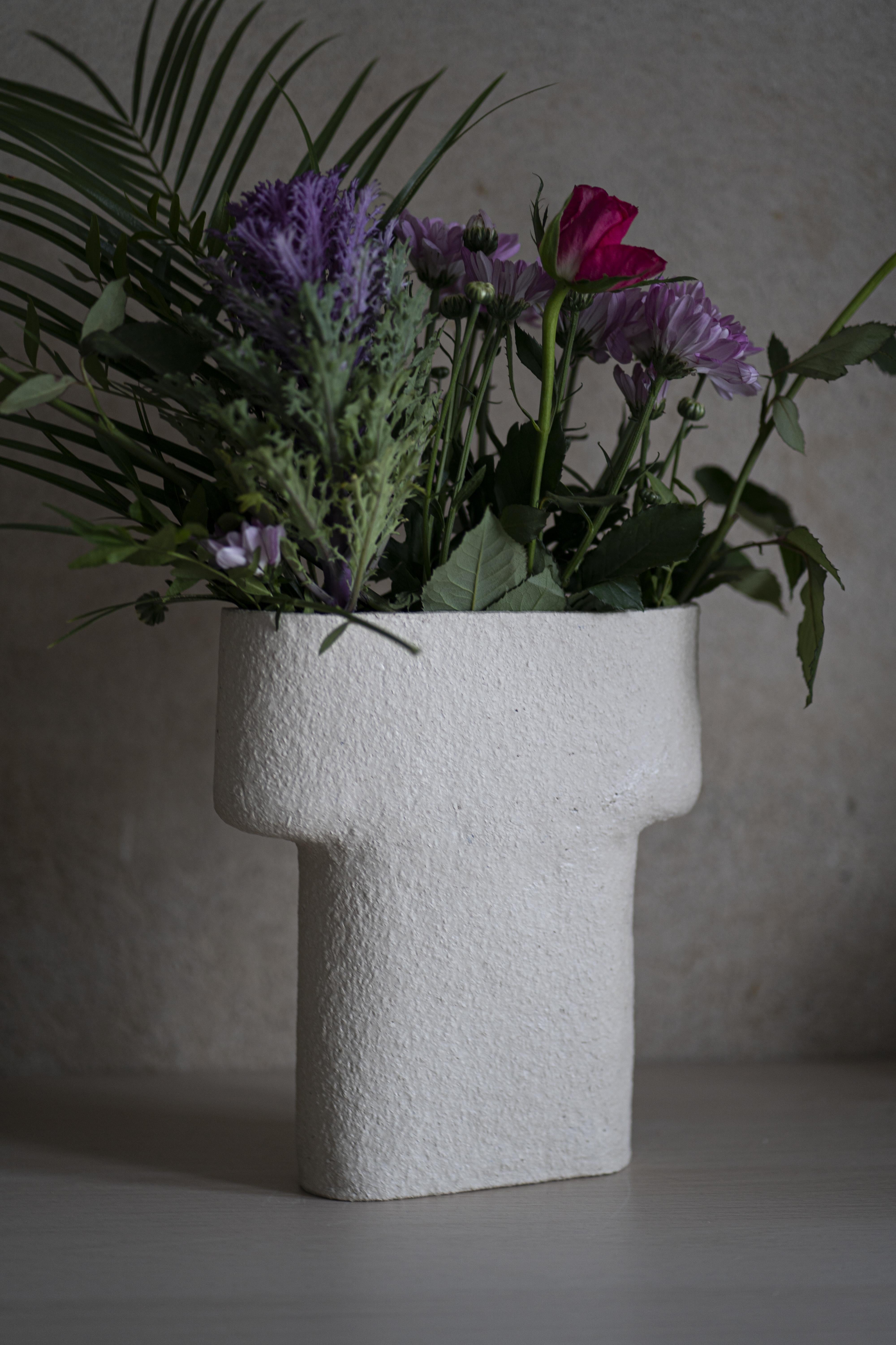 Pillar-vase takes inspiration from the ancient human-made rock formations. It references the ancient architecture and the human touch in carved stones. The sculptural vase displays flowers in a horizontal fan-like alignment and the electric blue