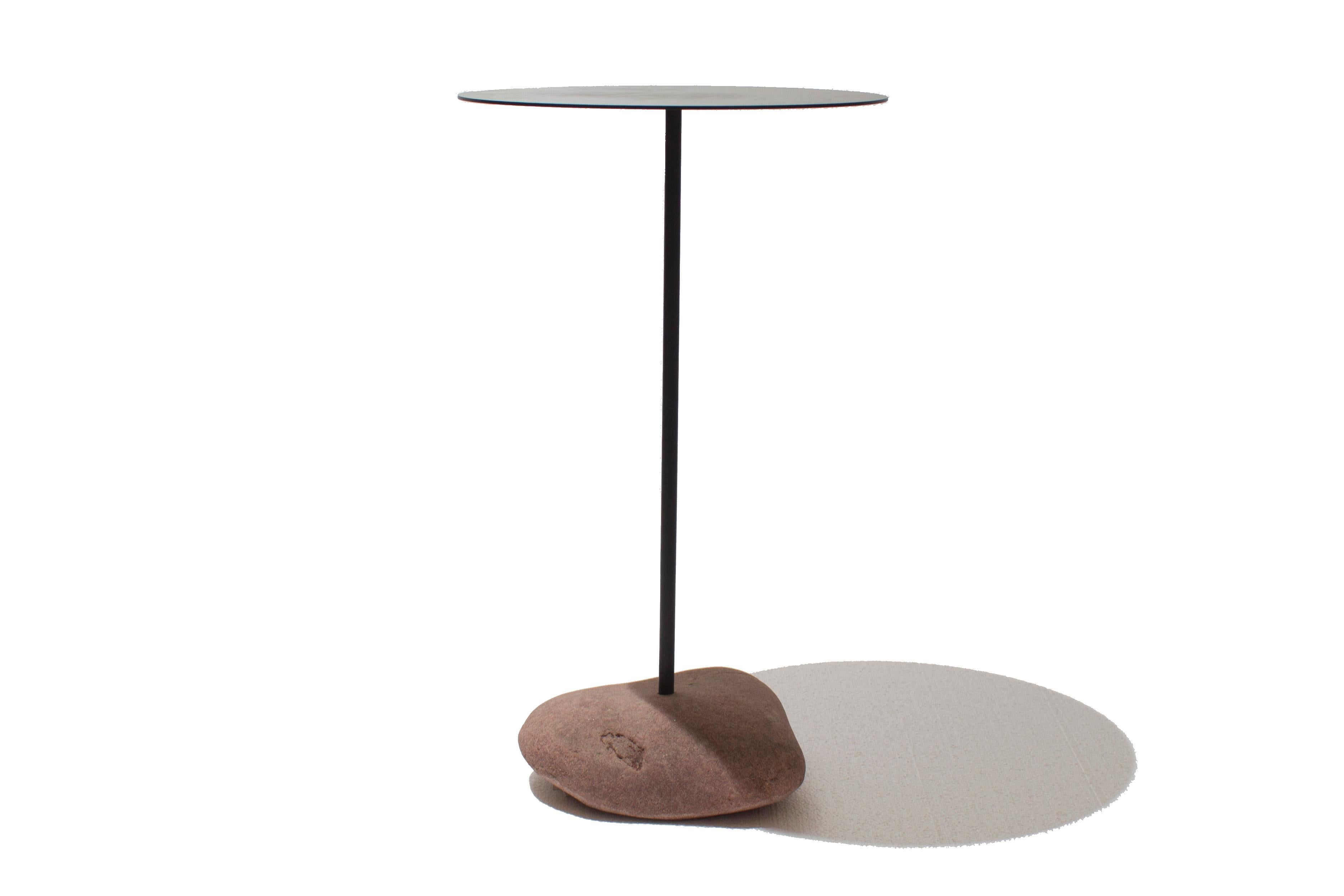 Cette nouvelle table d'appoint d'intérieur/extérieur s'inspire du style moderne minimal avec des détails terreux. La juxtaposition de la pierre naturelle et du plateau en acier revêtu de poudre noire matte crée un équilibre de texture et de